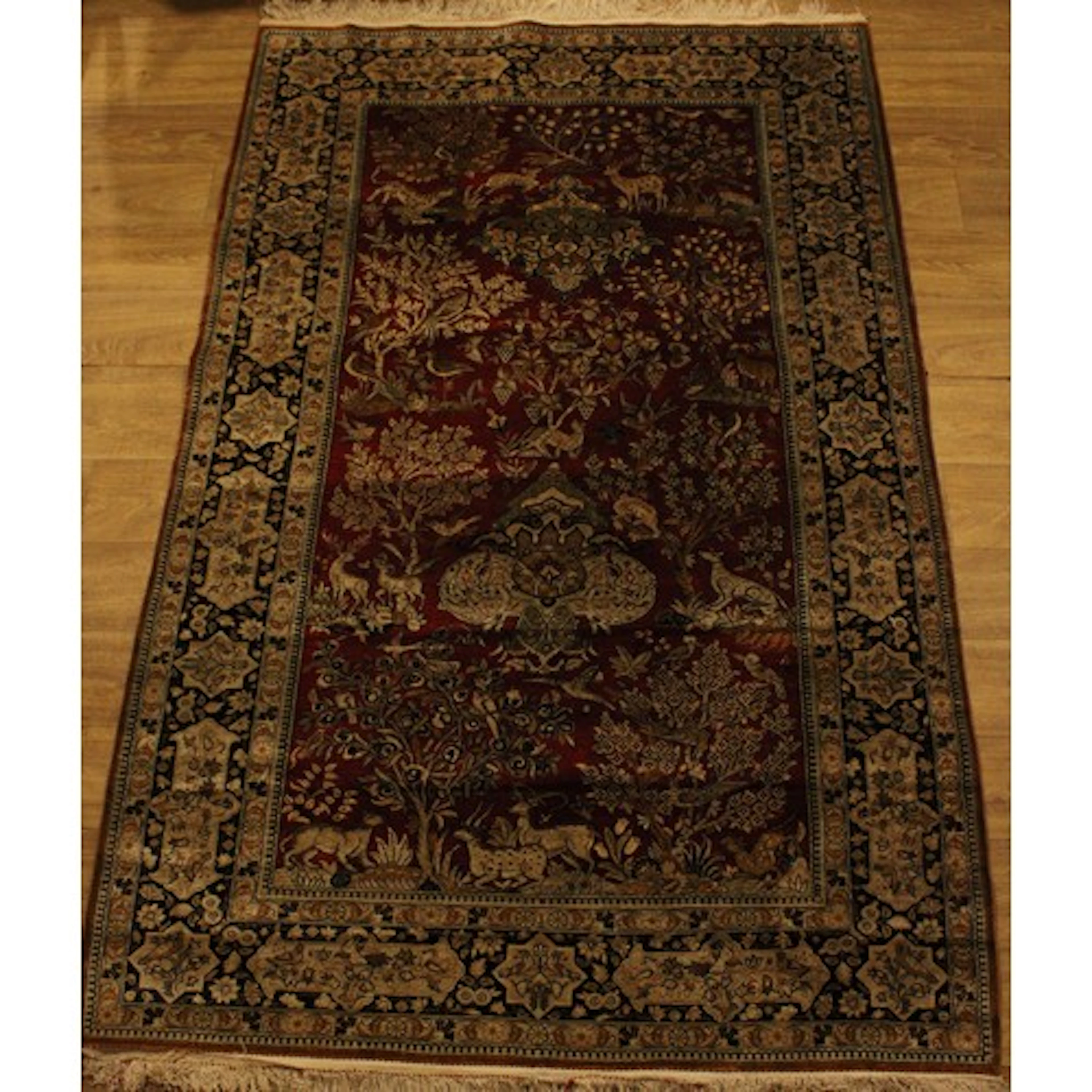 A Persian silk Qum rug, profusely worked with animals, tree ...