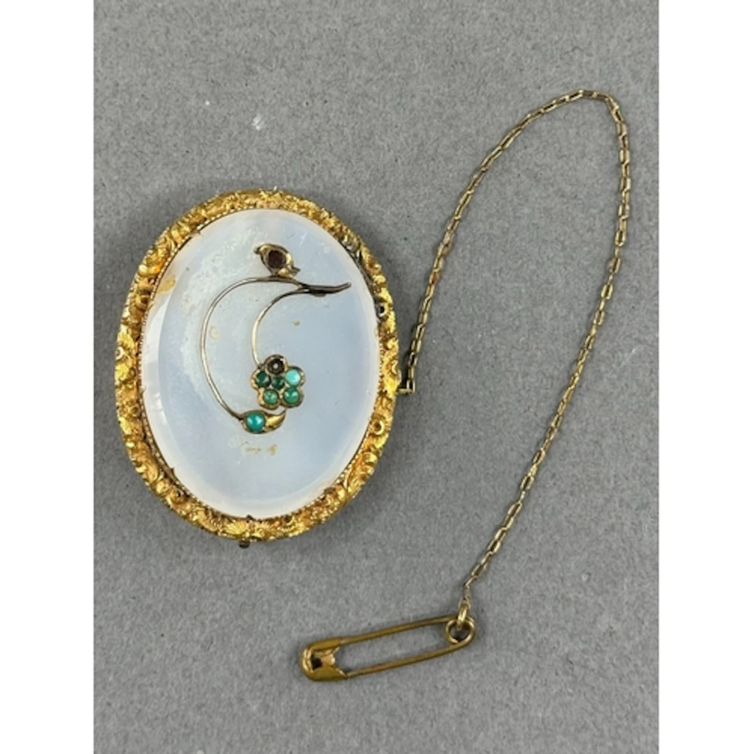 Jewellery: a yellow metal and chalcedony floral brooch, the ...