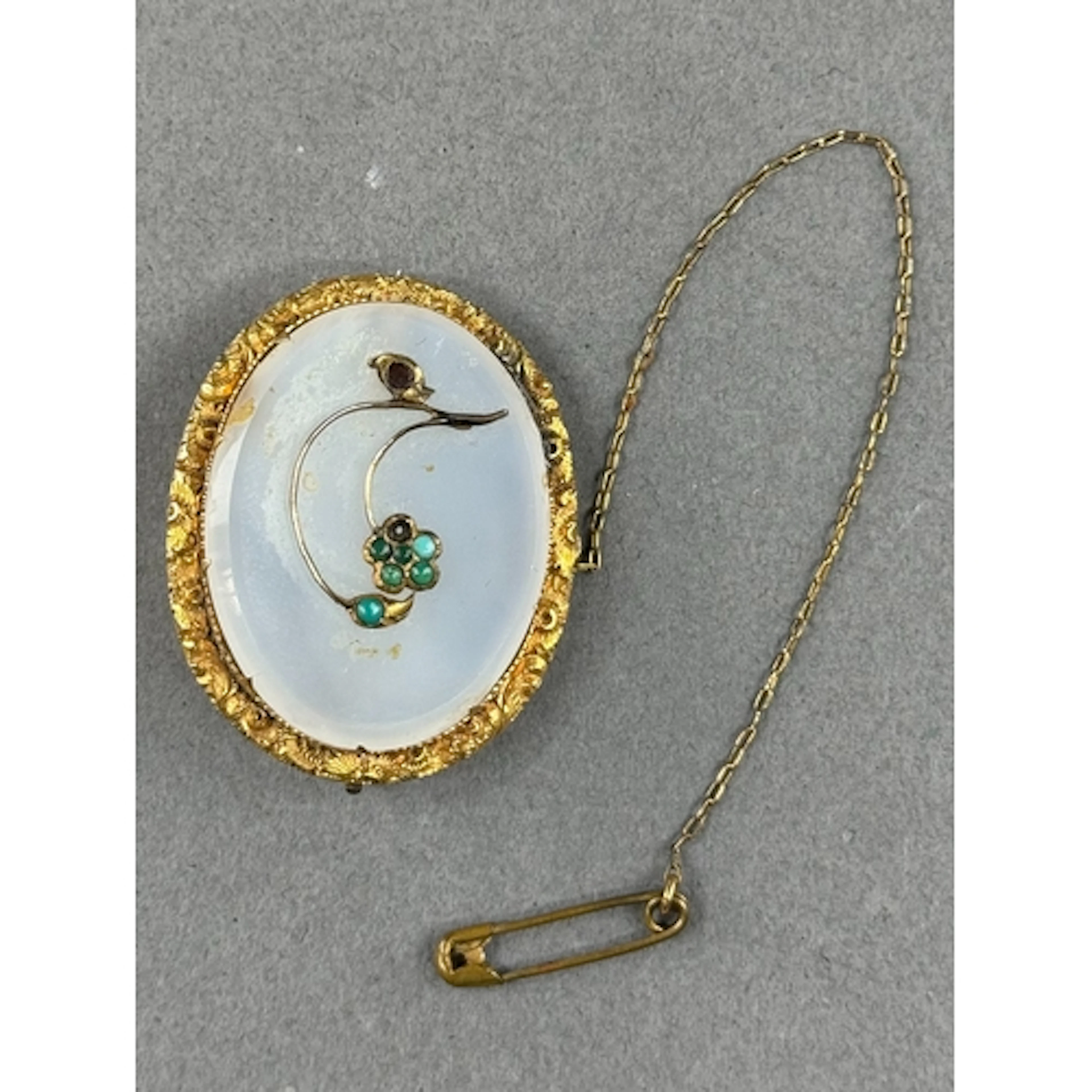 Jewellery: a yellow metal and chalcedony floral brooch, the ...