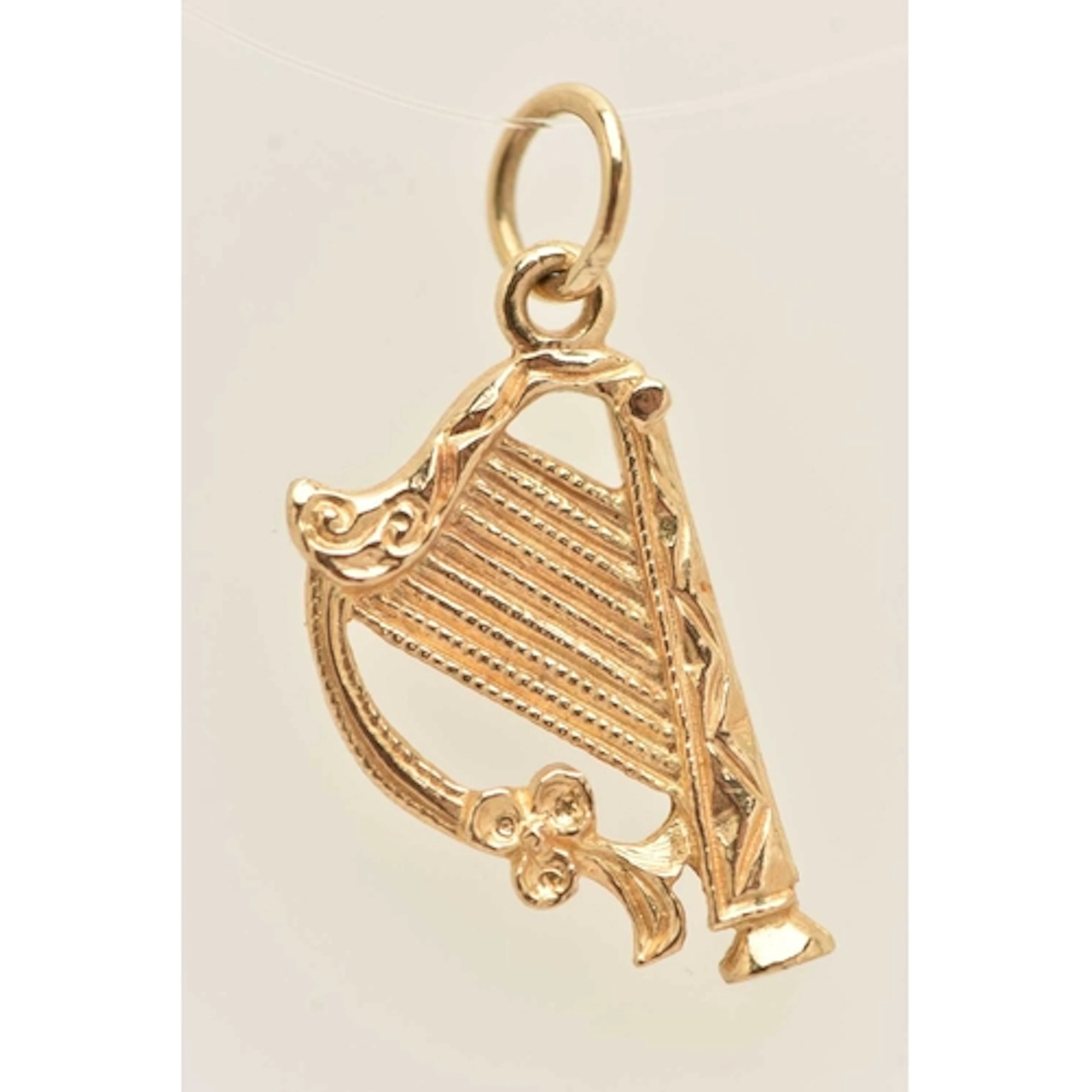 A 9CT GOLD HARP PENDANT, fitted with a jump ring for suspens...