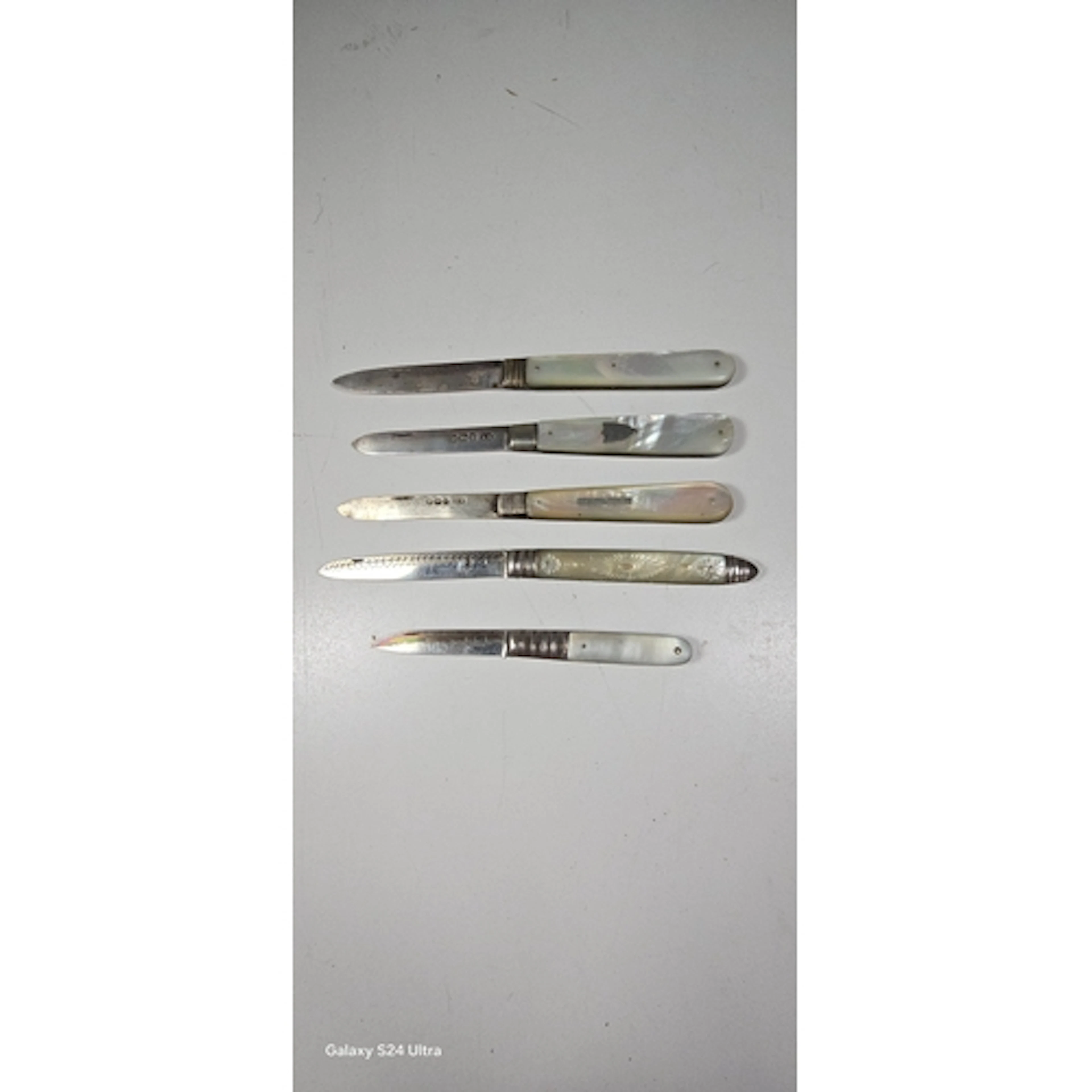 Five folding fruit knives with silver blades, three with She...