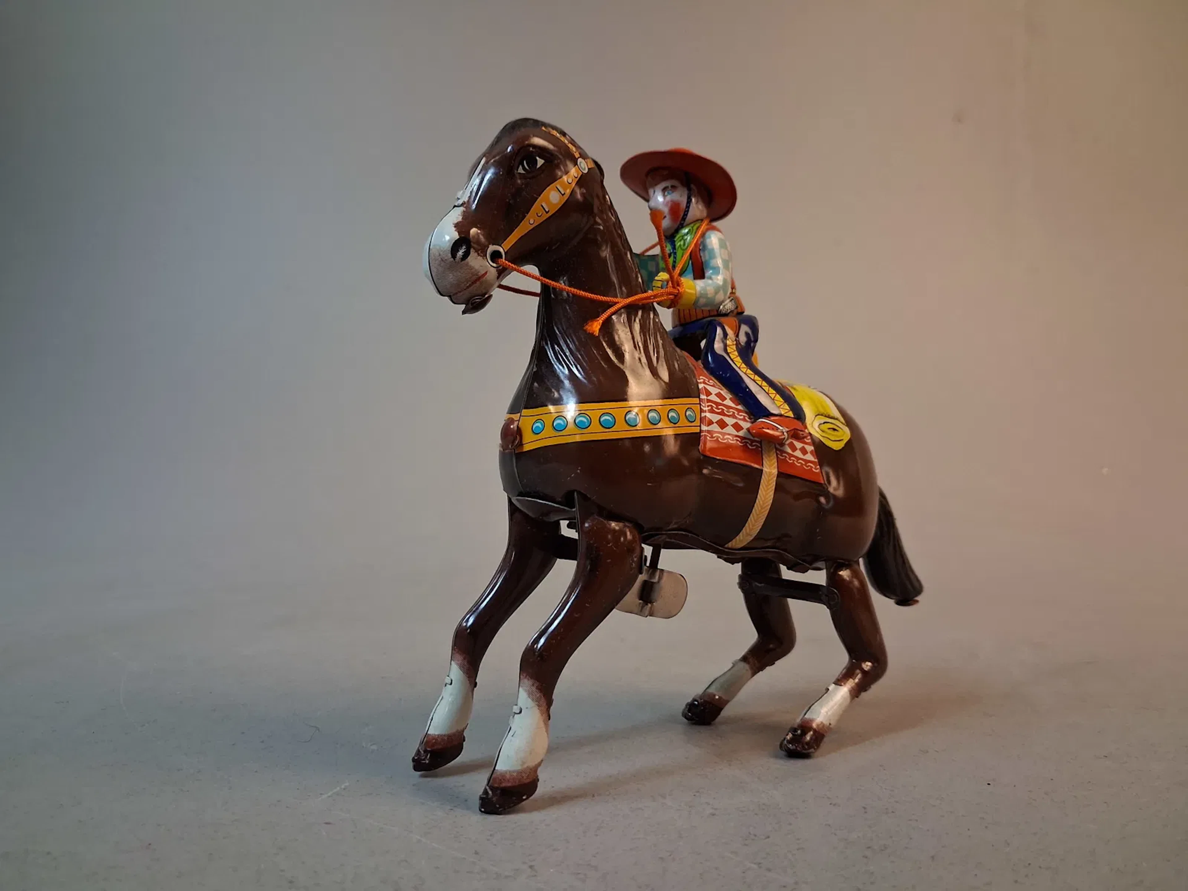 Plårleksak. "Cowboy med häst", Litograferad plåt, Haji, Japan.