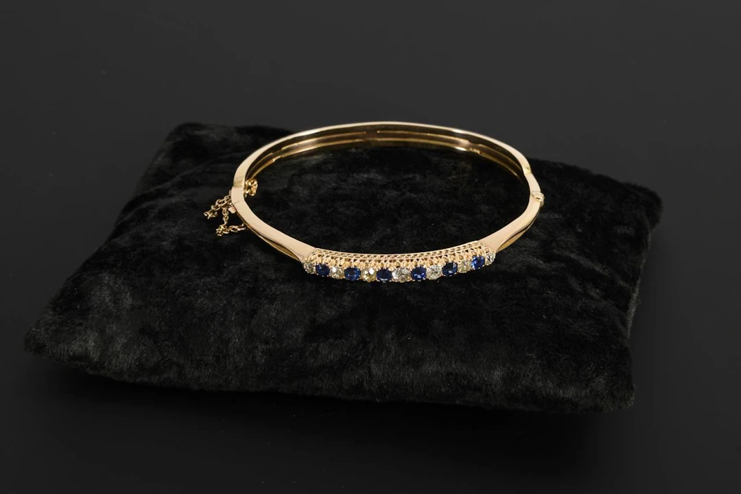 High-quality bangle with old-cut diamonds and blue gemstones, likely sapphires.