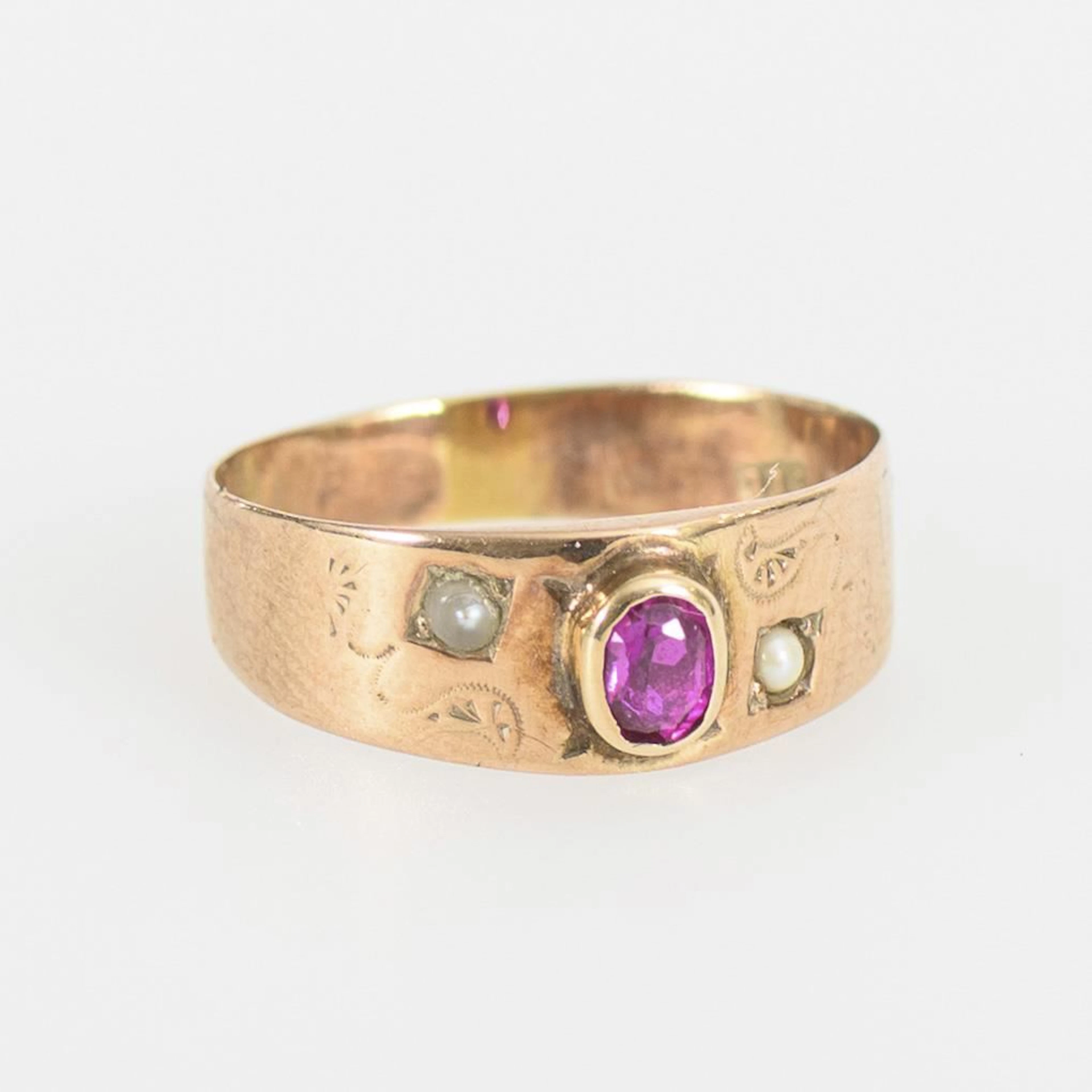 Very small ring with a red gemstone and seed pearls.