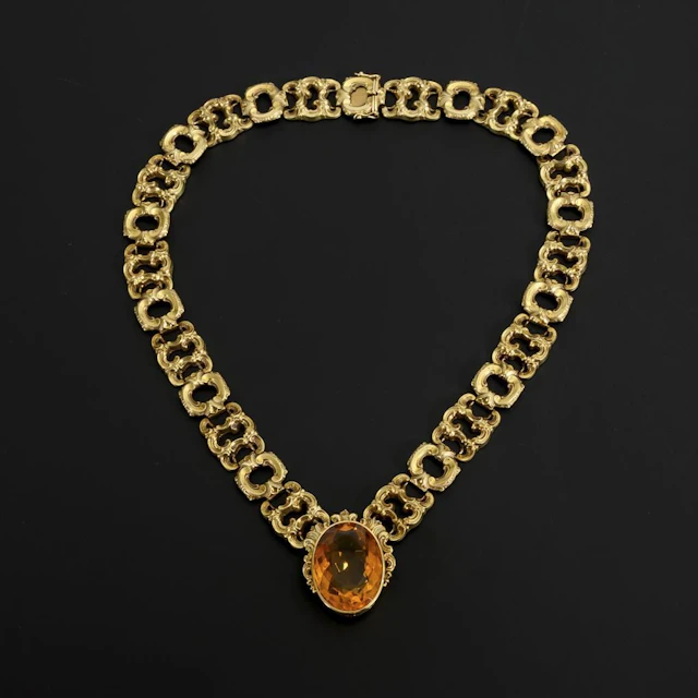 Necklace with a large orange gemstone, likely citrine.