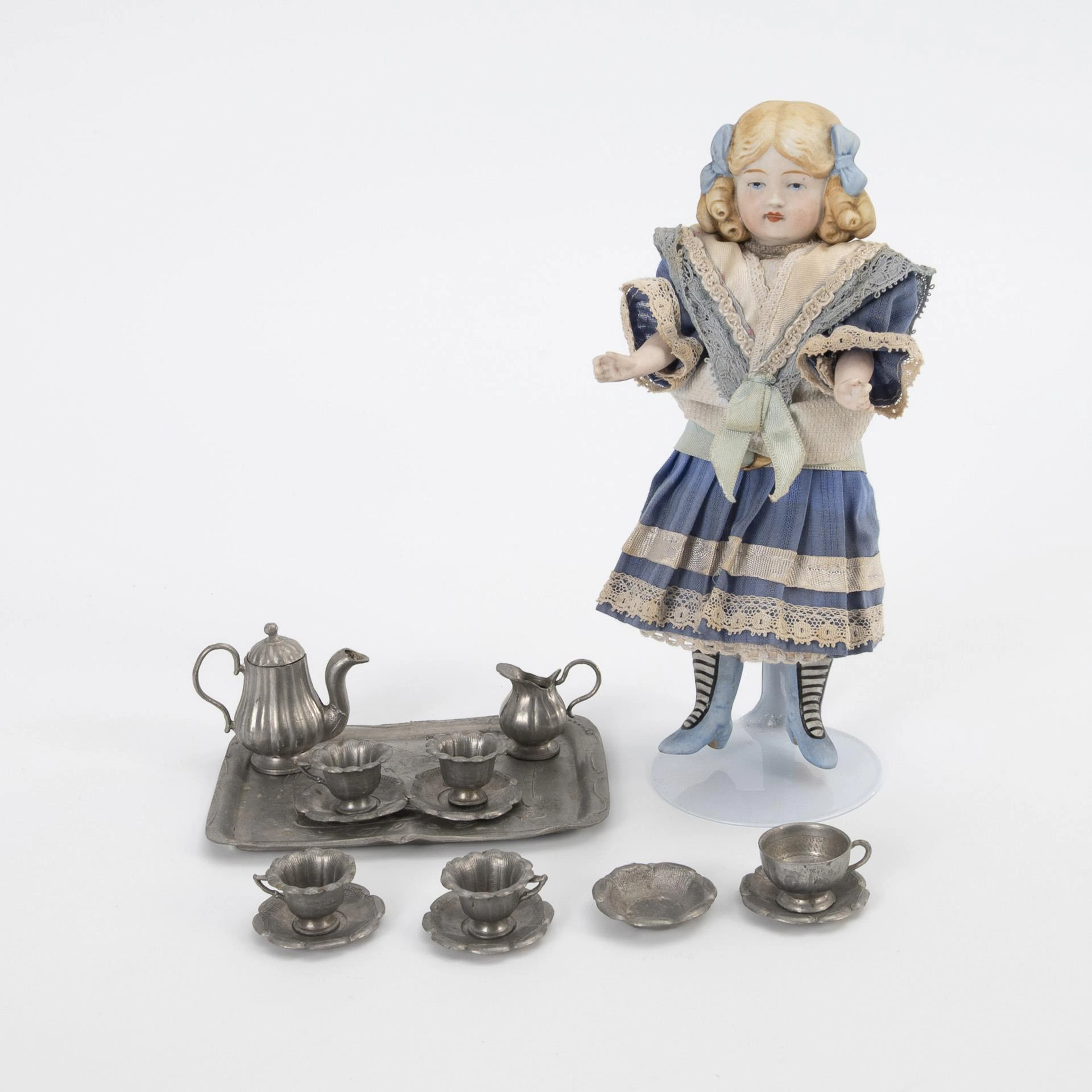All-bisque doll and miniature pewter dishes.