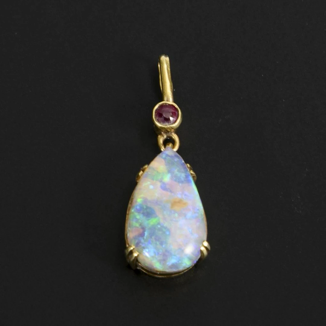 Small pendant with a solid opal and a red gemstone, likely a ruby.