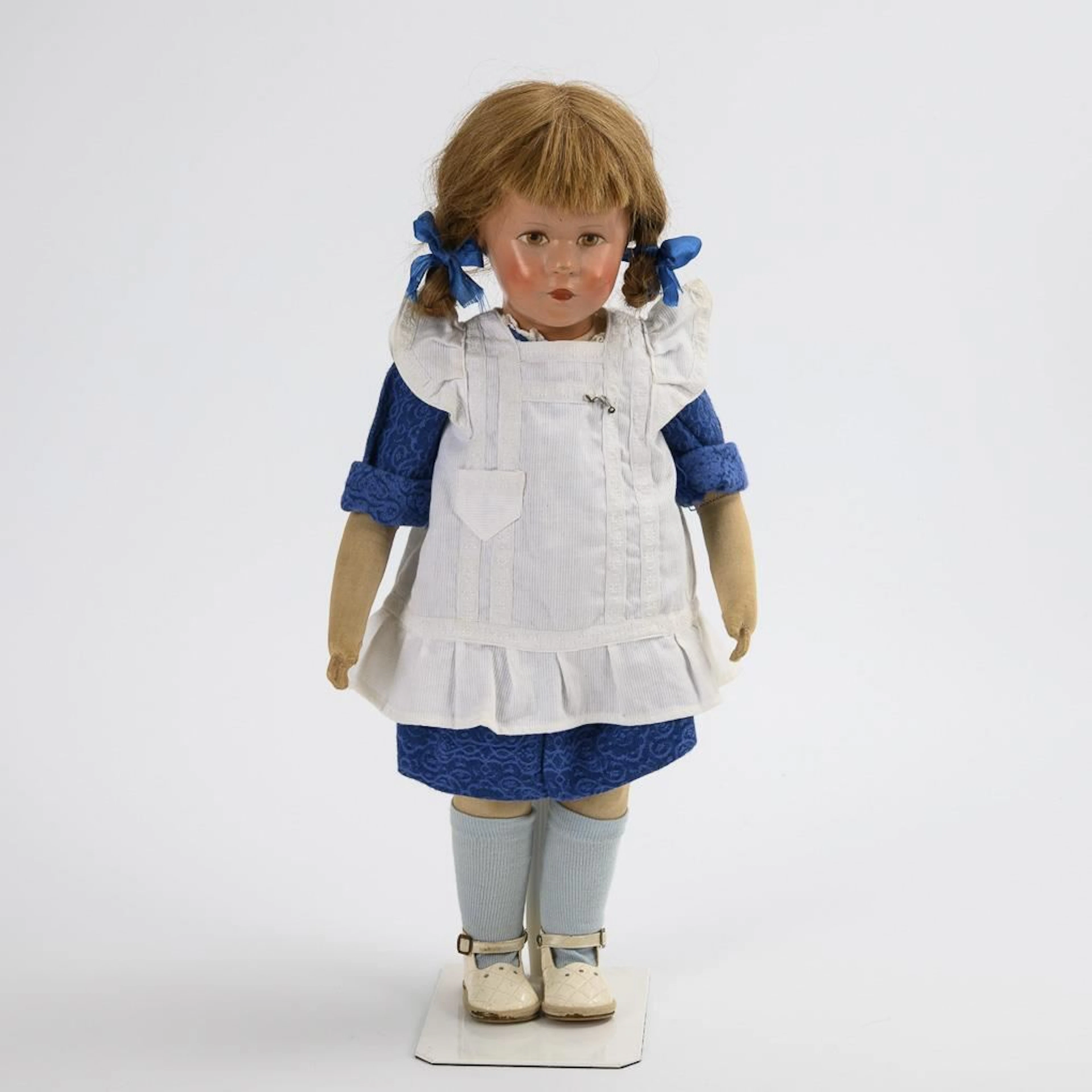 Girl's doll with a white apron. Käthe Kruse.