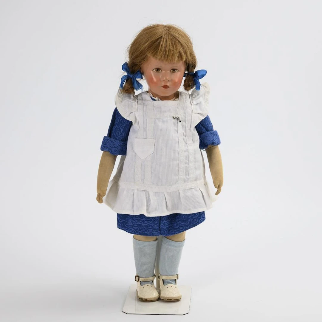 Girl's doll with a white apron. Käthe Kruse.