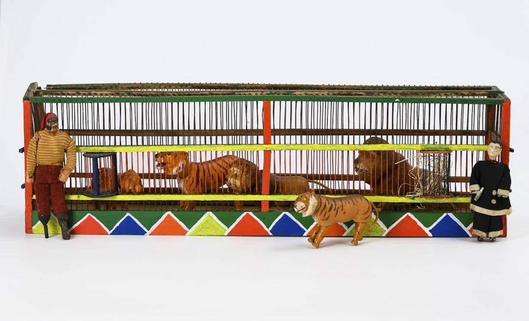 5 Humpty Dumpty animals and 2 figures in a predator cage. Albert Schoenhut.