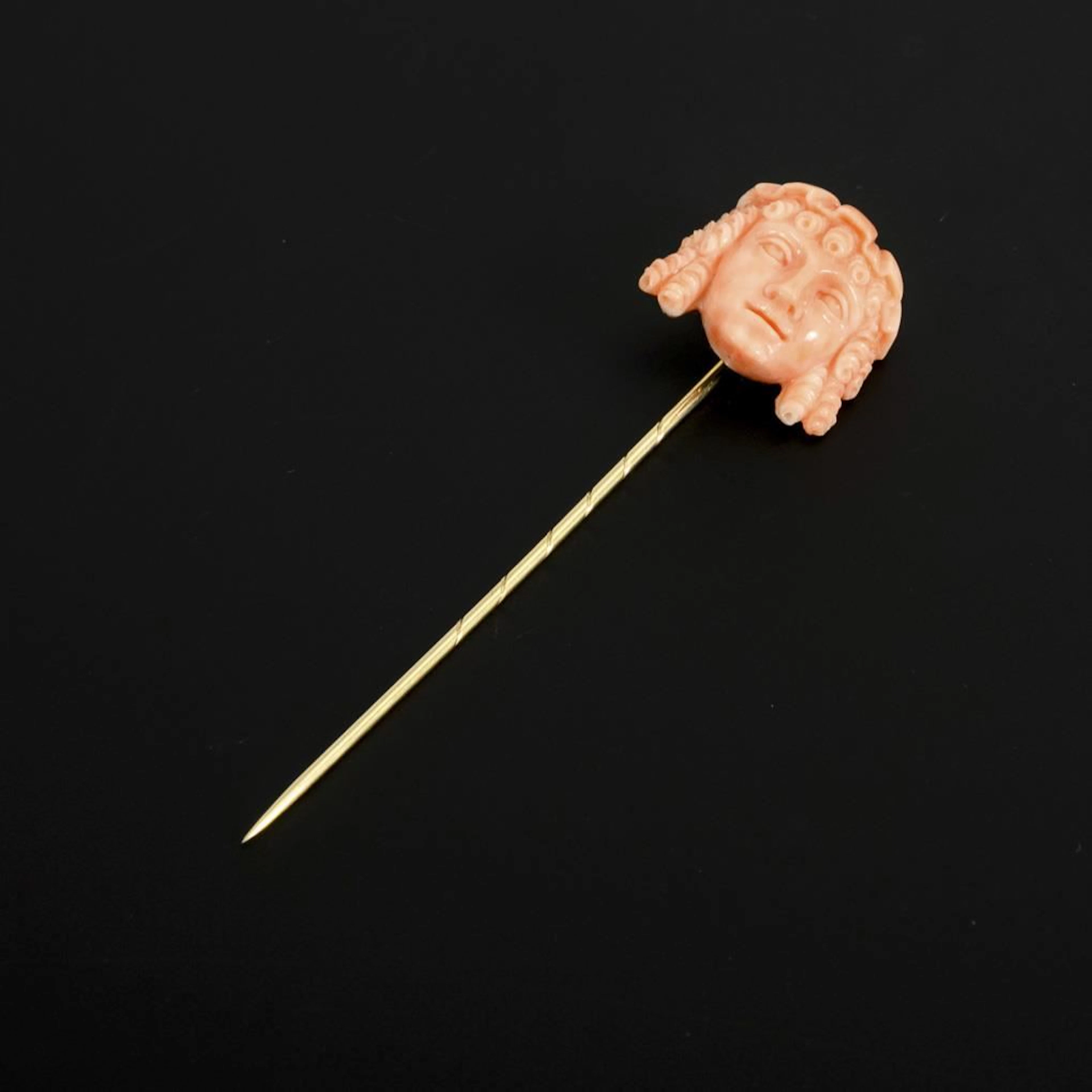 Pin with a coral carving in the Greek style.