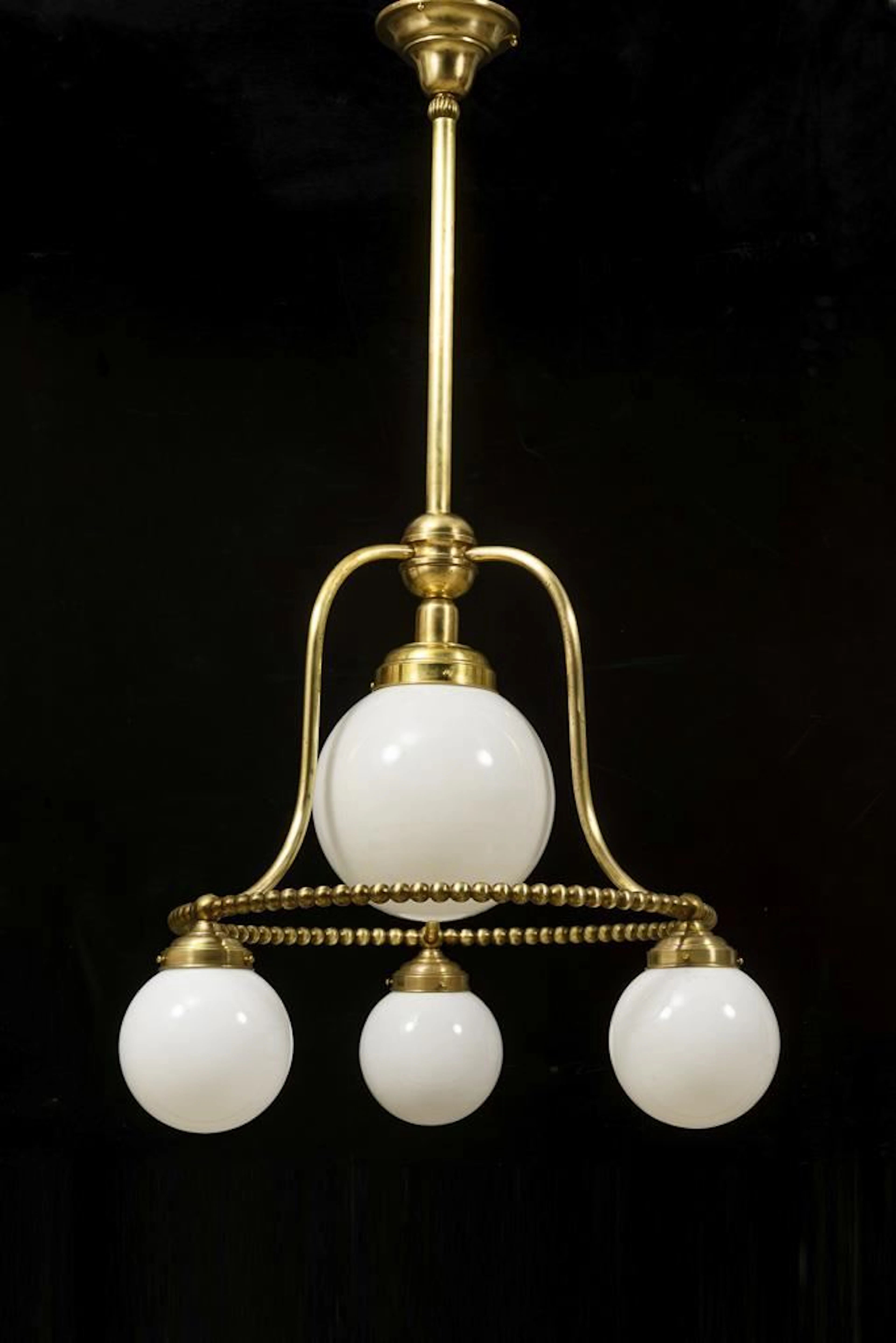 Large ceiling lamp with white spherical shades.