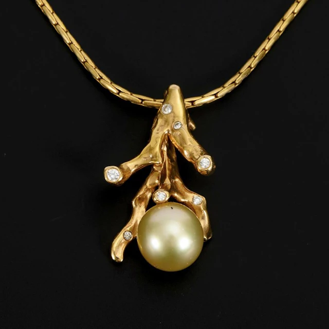 Coral-shaped pendant with a pearl on a chain.