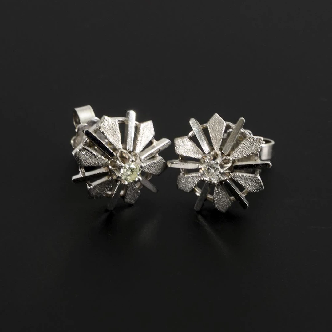 Pair of modernist stud earrings with brilliant-cut diamonds.
