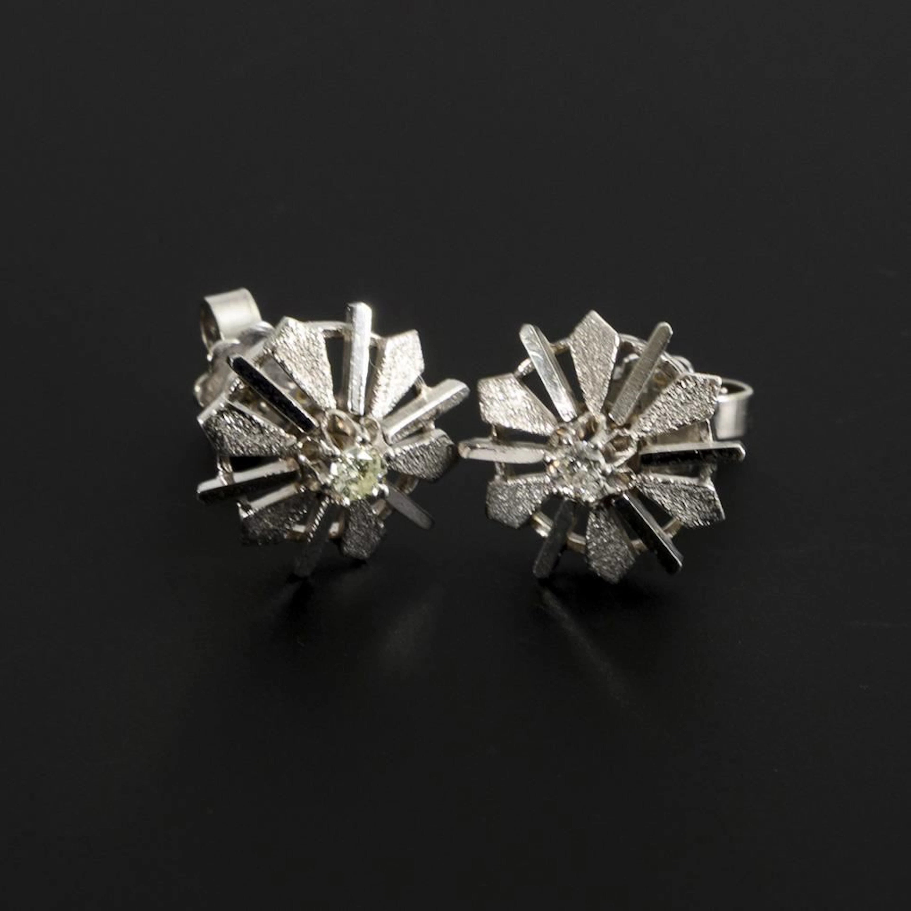 Pair of modernist stud earrings with brilliant-cut diamonds.