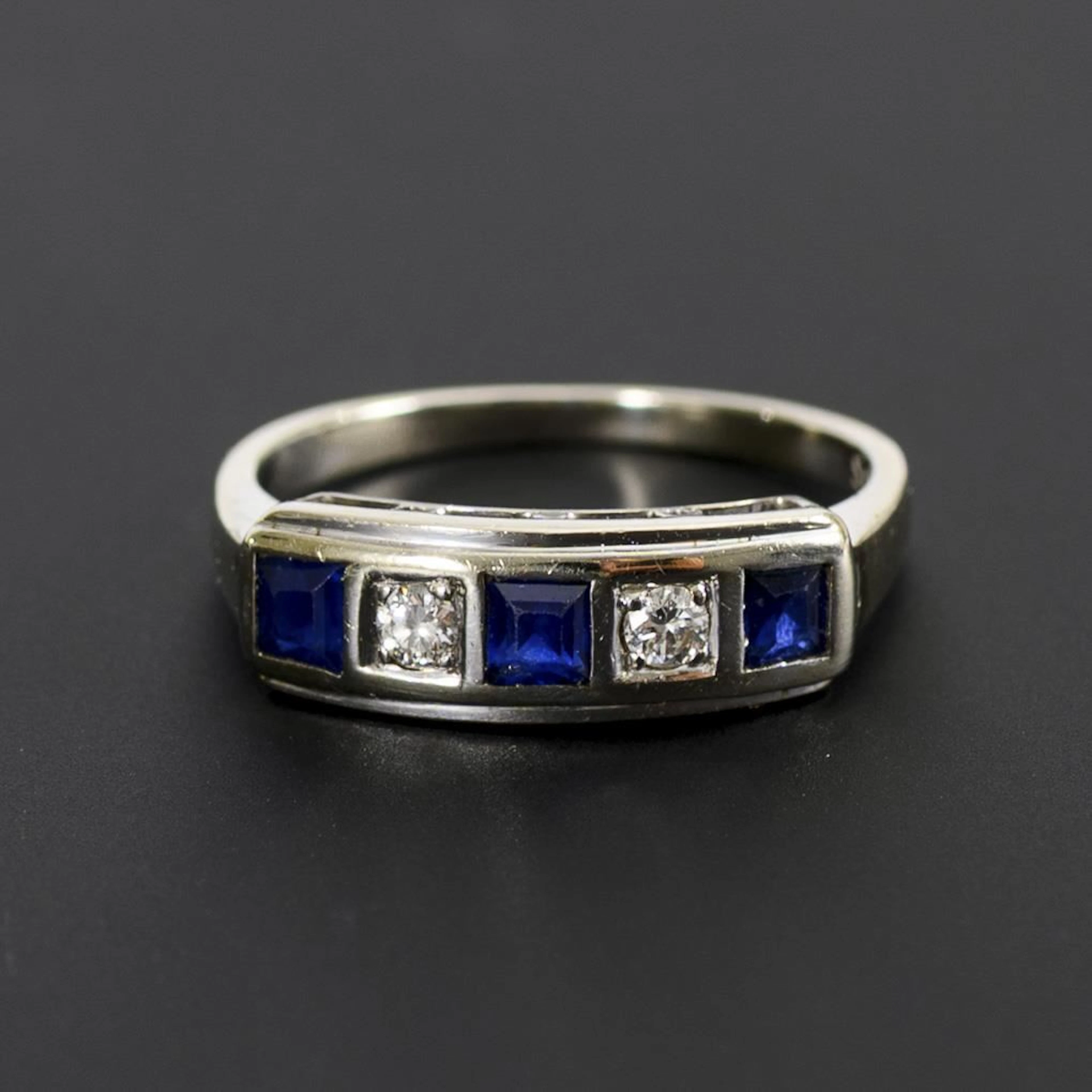 Art Deco ring with square blue gemstones, likely sapphires, and brilliant-cut