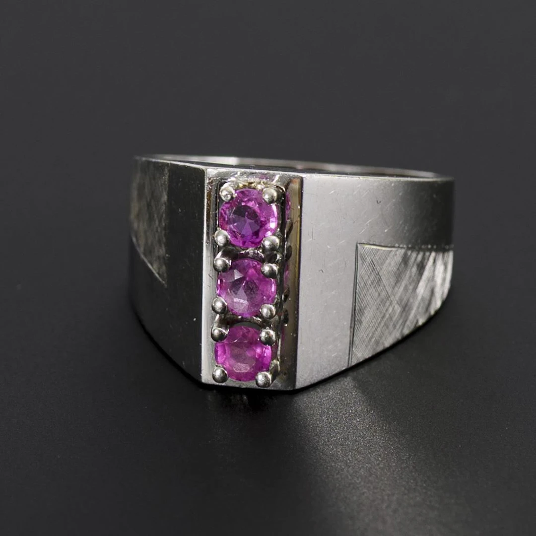 Modern ring with pink gemstones, likely rubies.