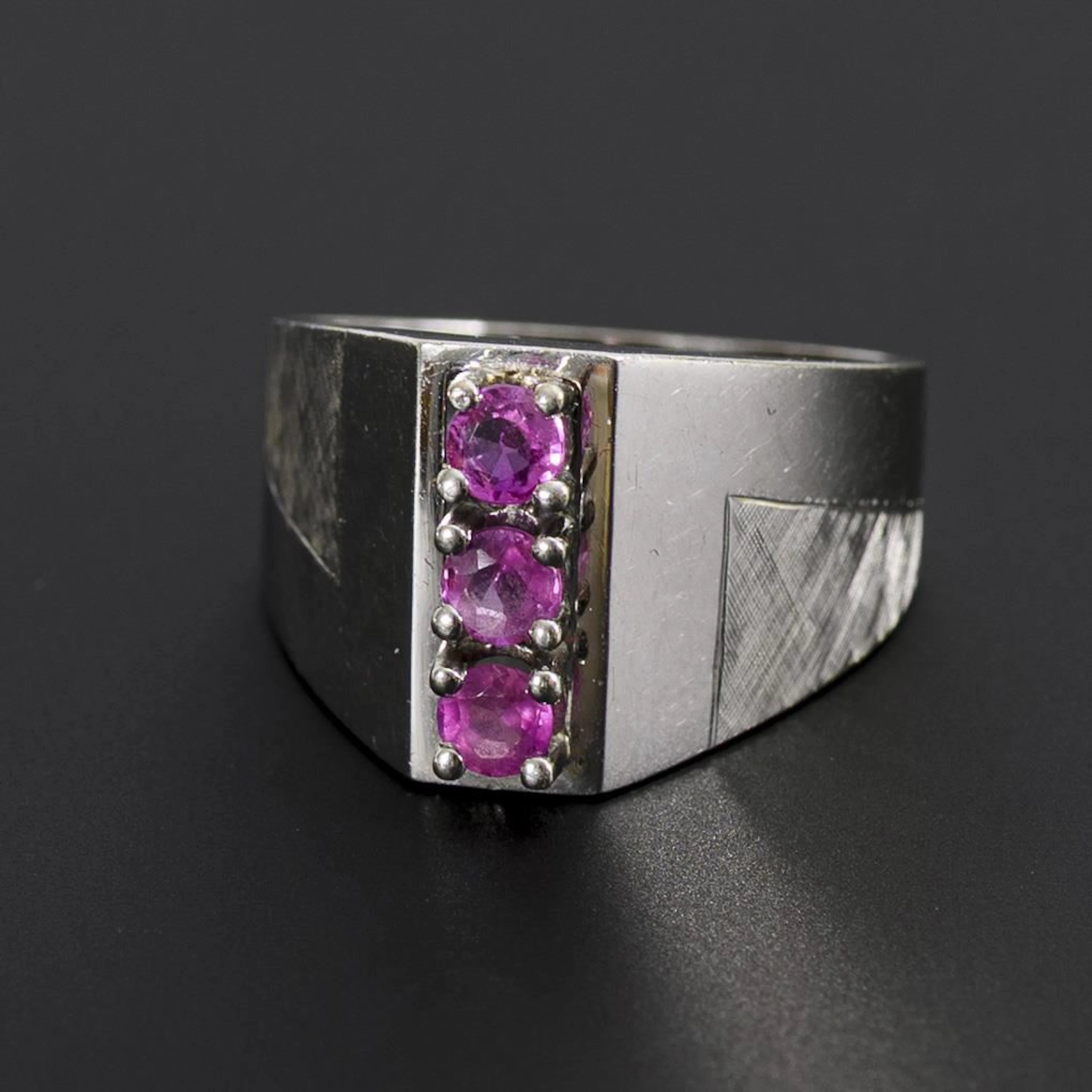 Modern ring with pink gemstones, likely rubies.