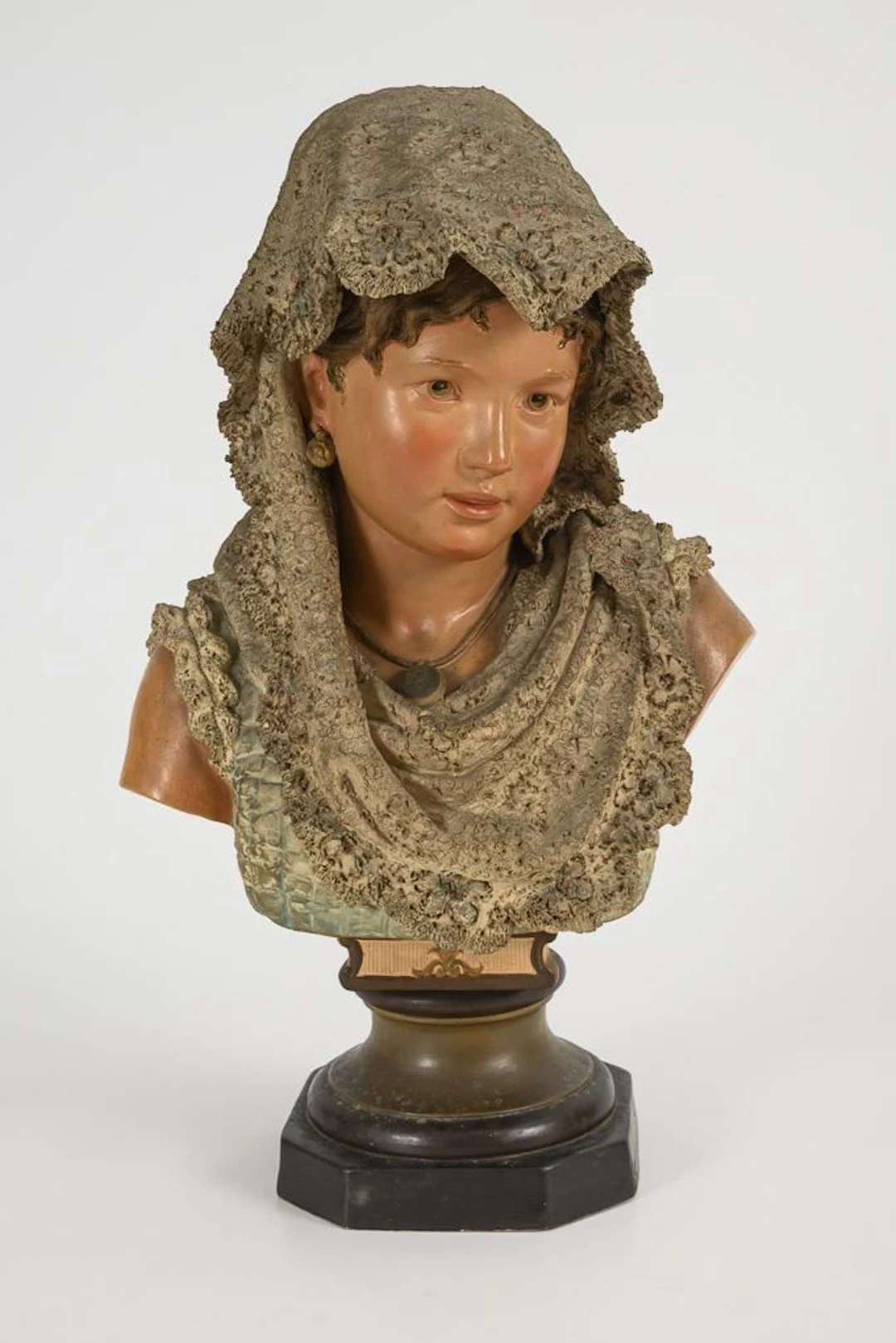 Bust of a girl wearing a lace scarf.