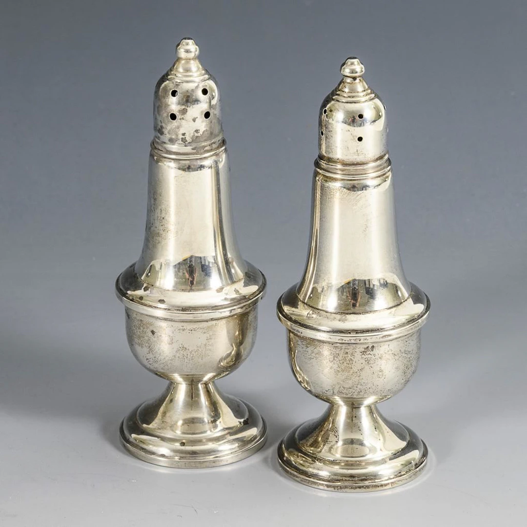 Pair of silver spice shakers.