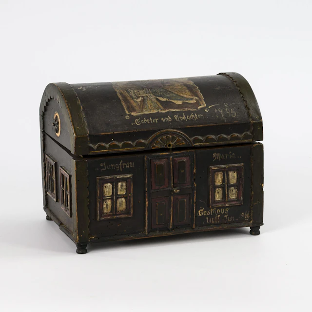 Small historicist round-lidded chest in the shape of a house.