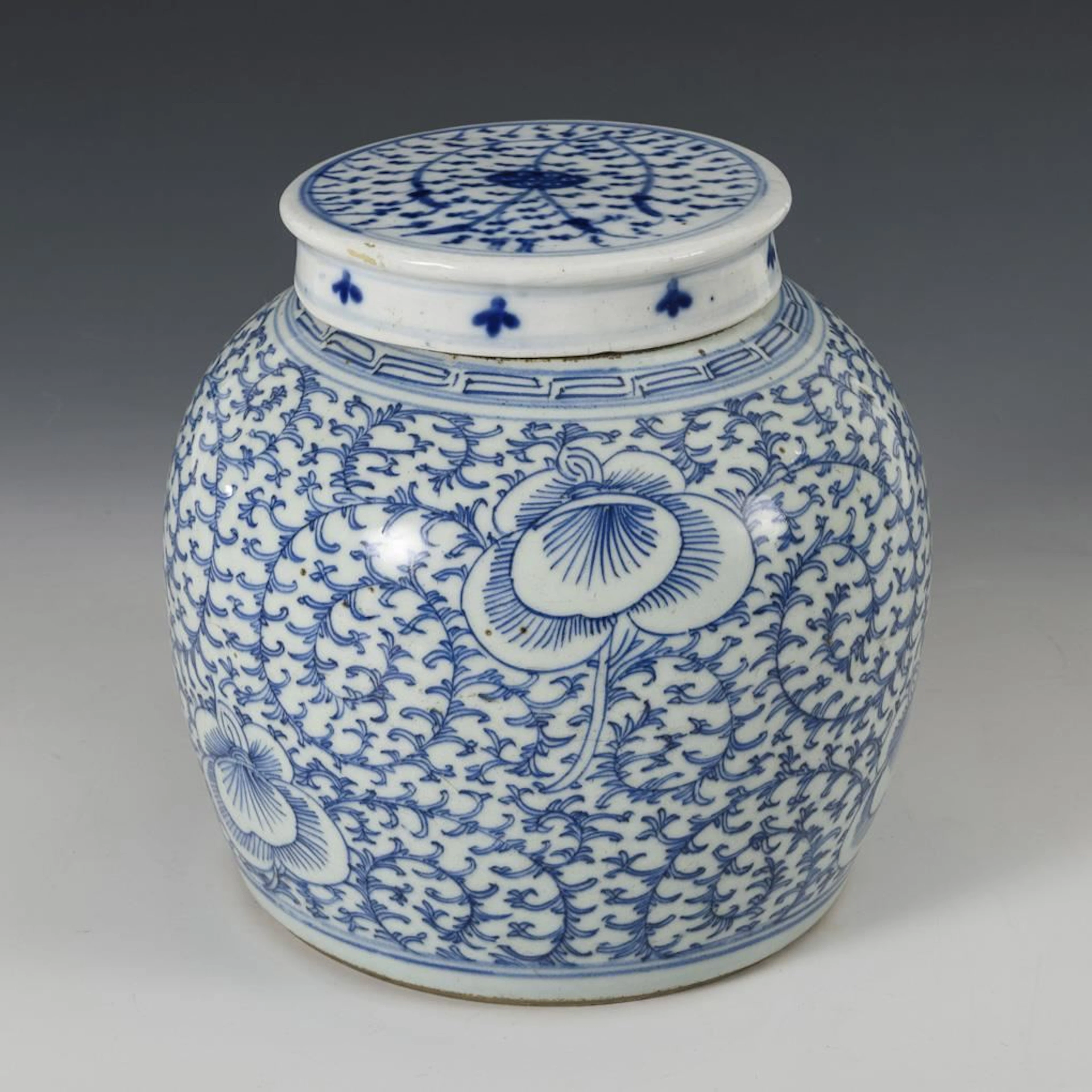 Lidded vase with blue vine motifs.