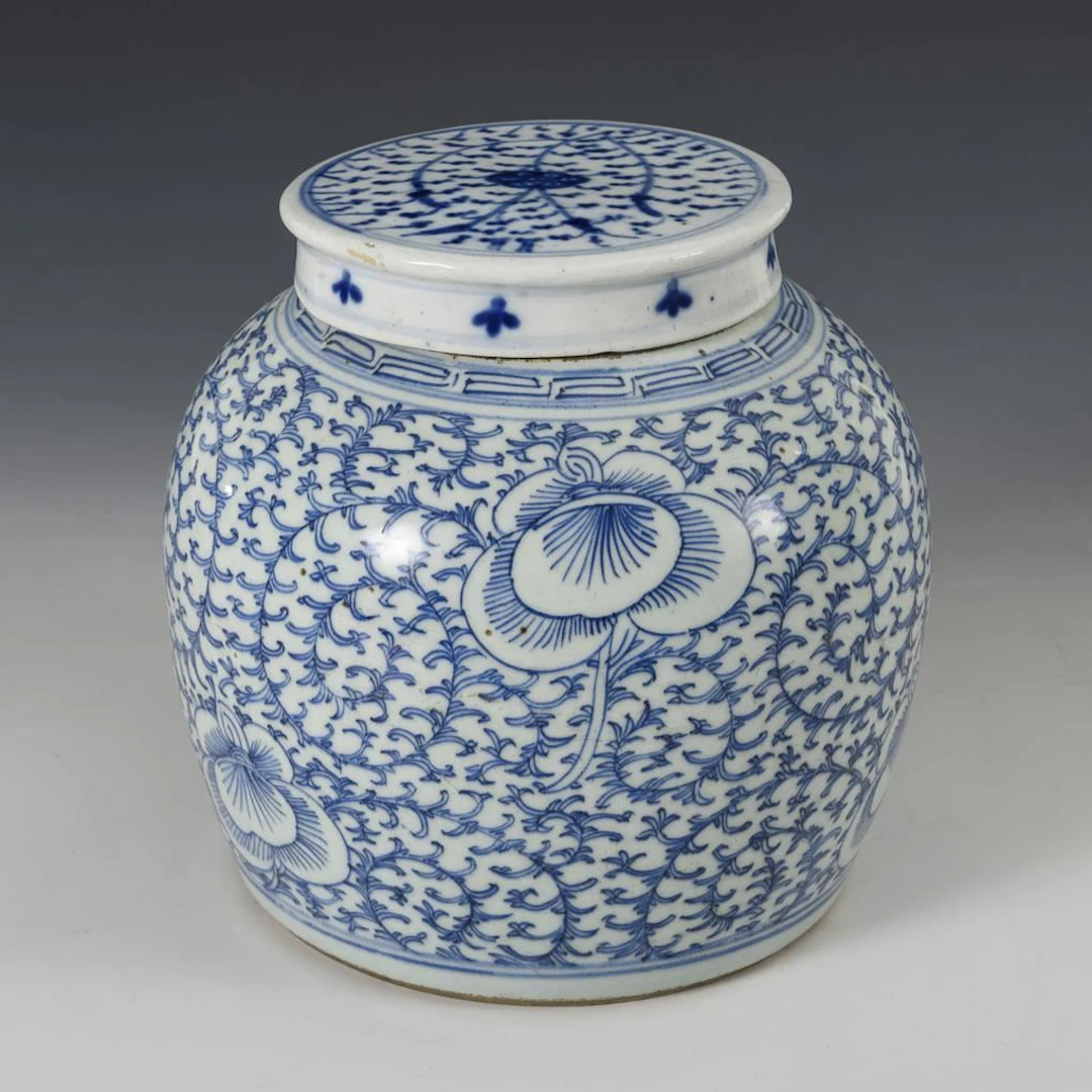 Lidded vase with blue vine motifs.