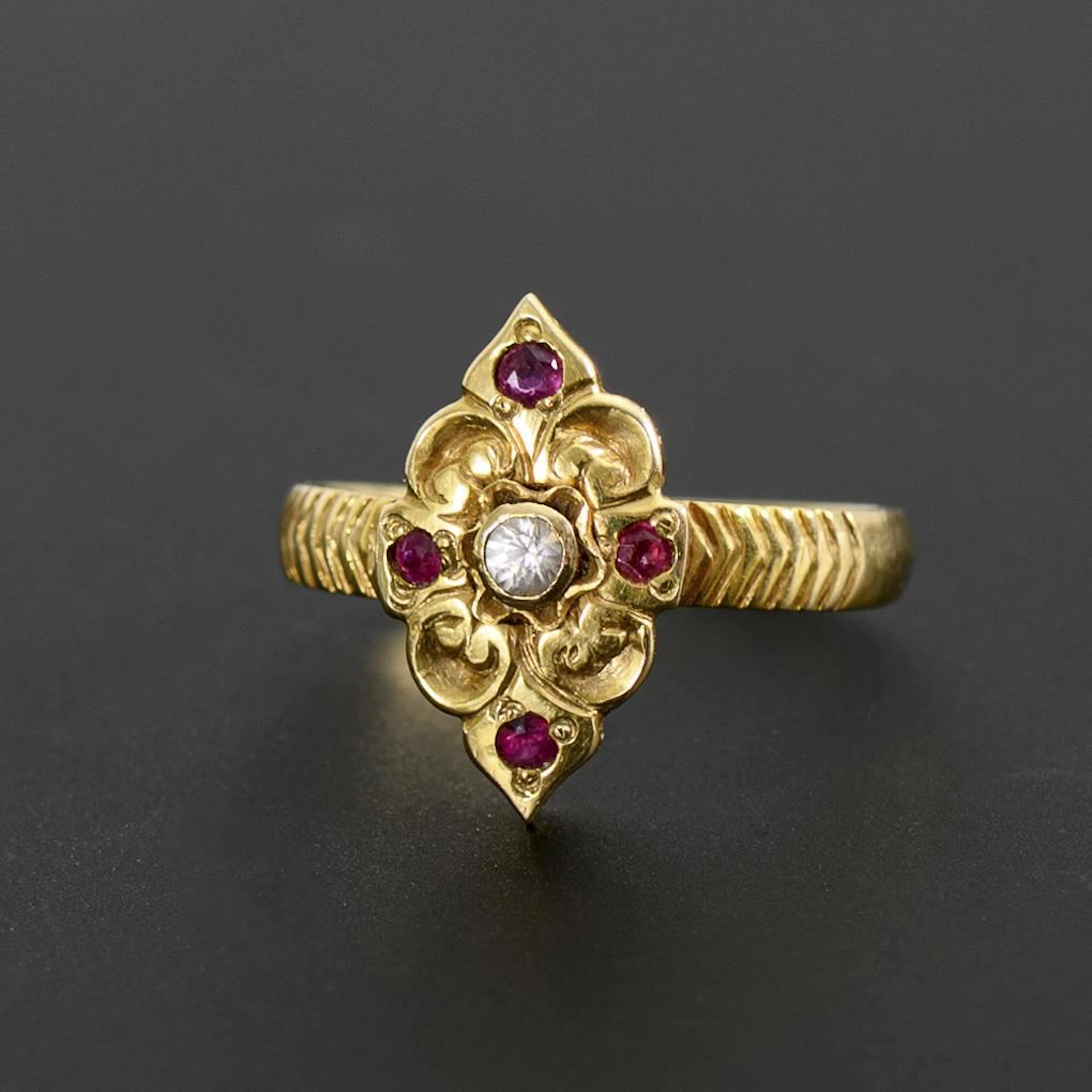 Very small ring with red gemstones or synthetic stones.