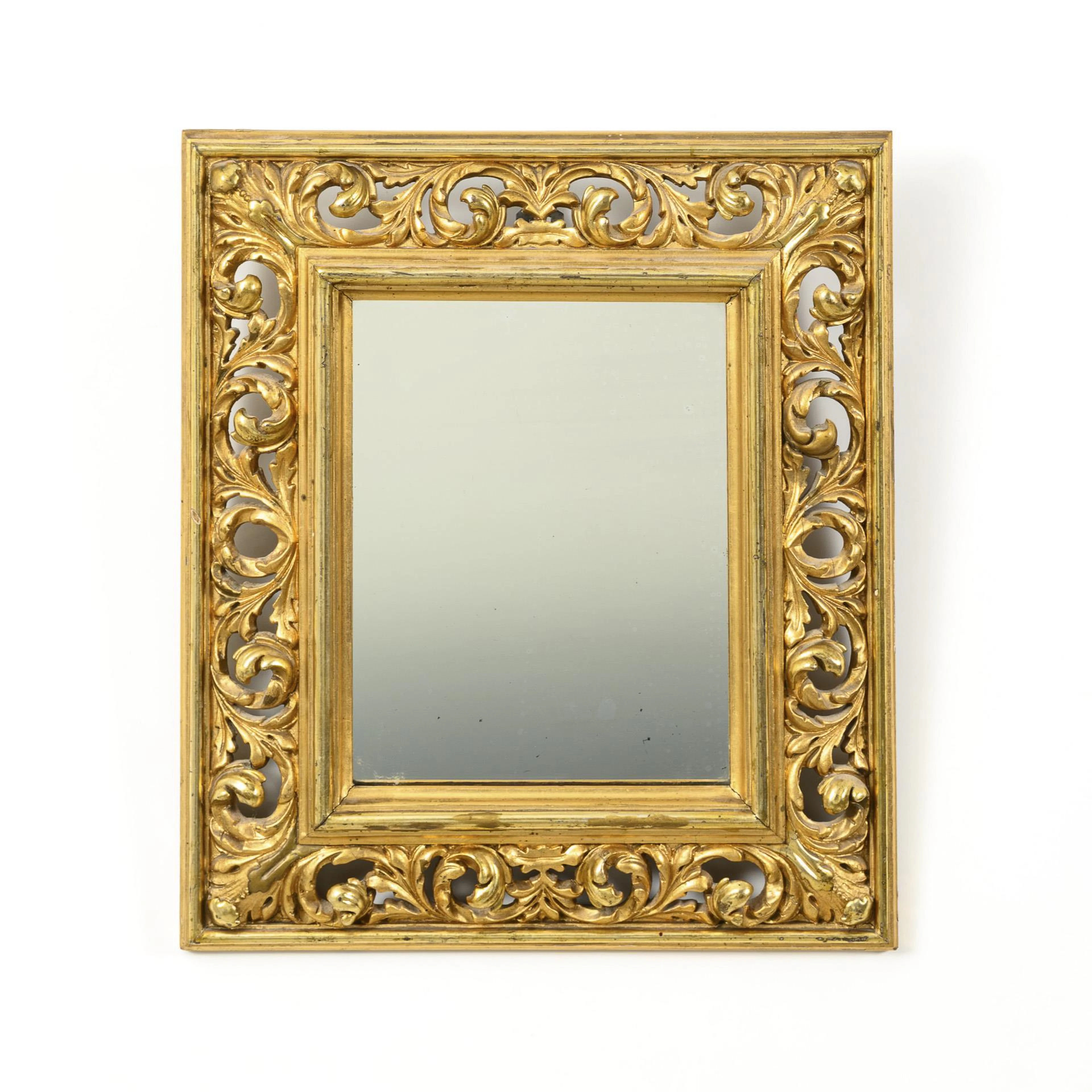 Small wall mirror in gold stucco frame.