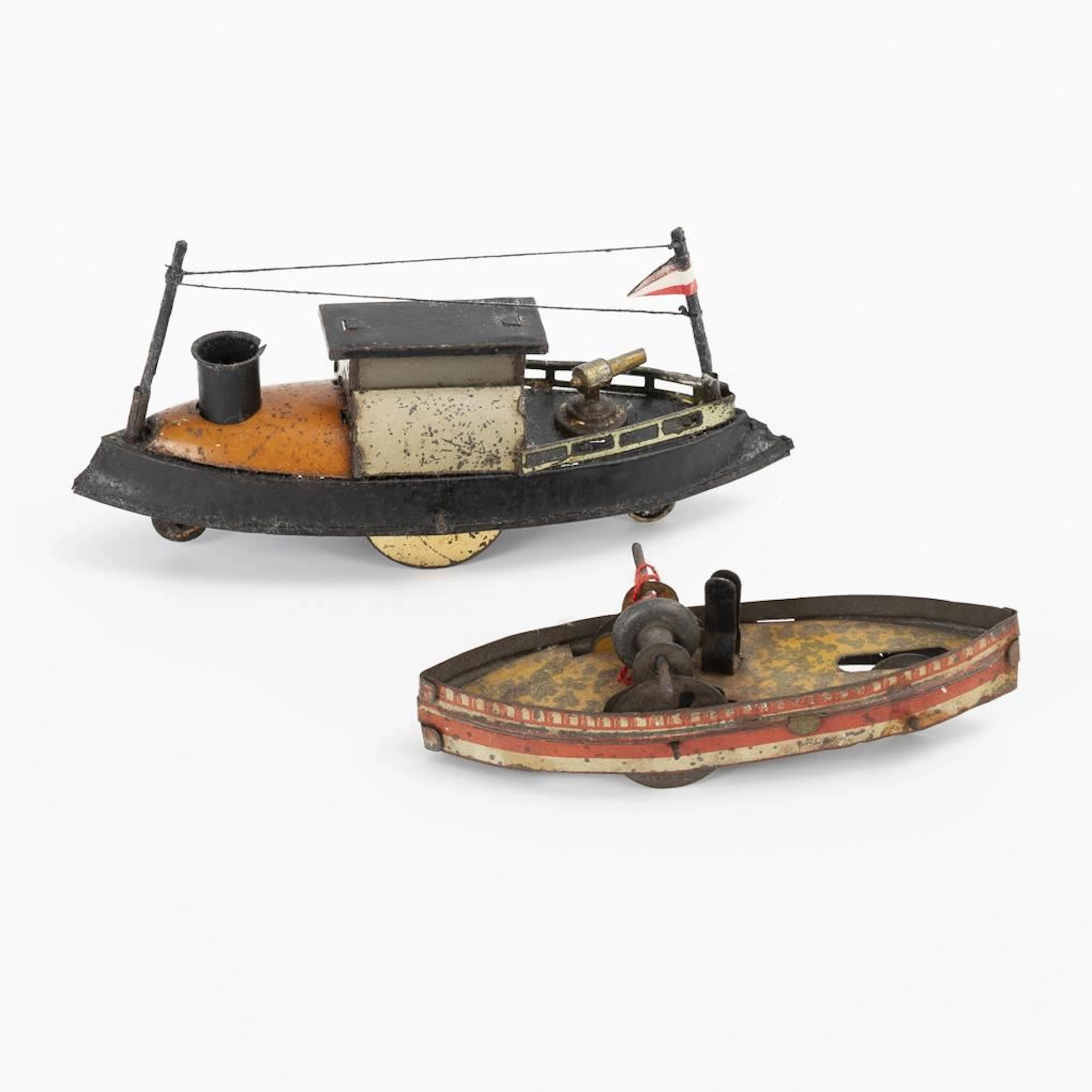 2 small tin ships on wheels.