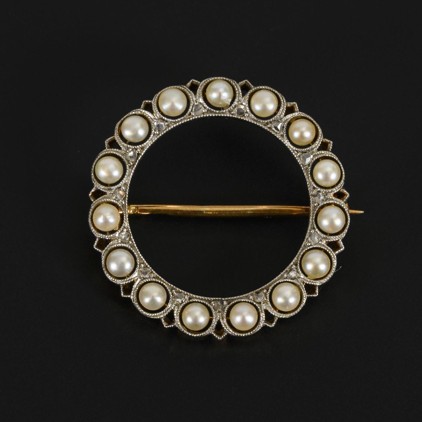 Small, round brooch set with pearls and diamonds.