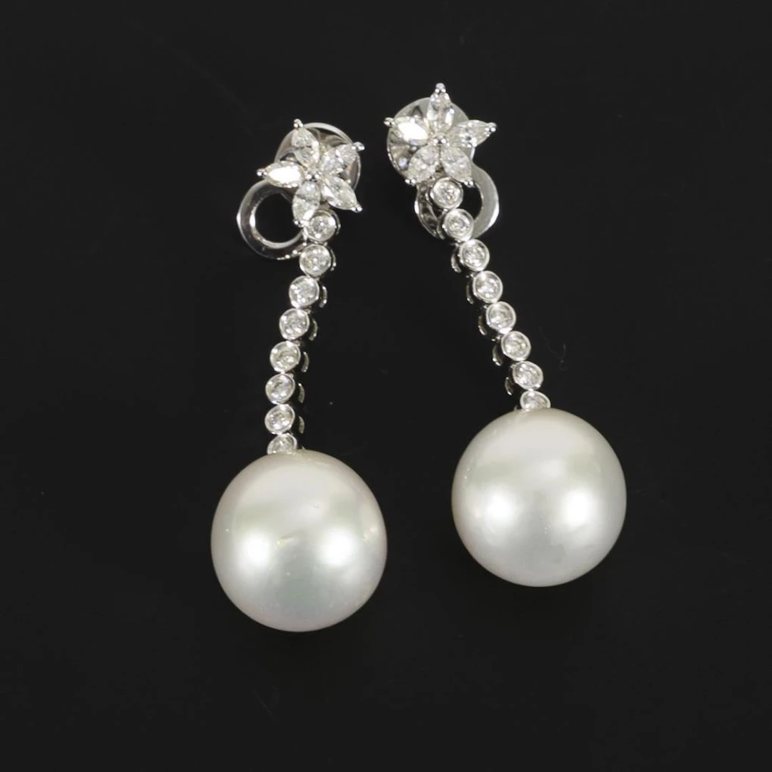 High-quality dangling earrings with pearls, likely South Sea pearls.
