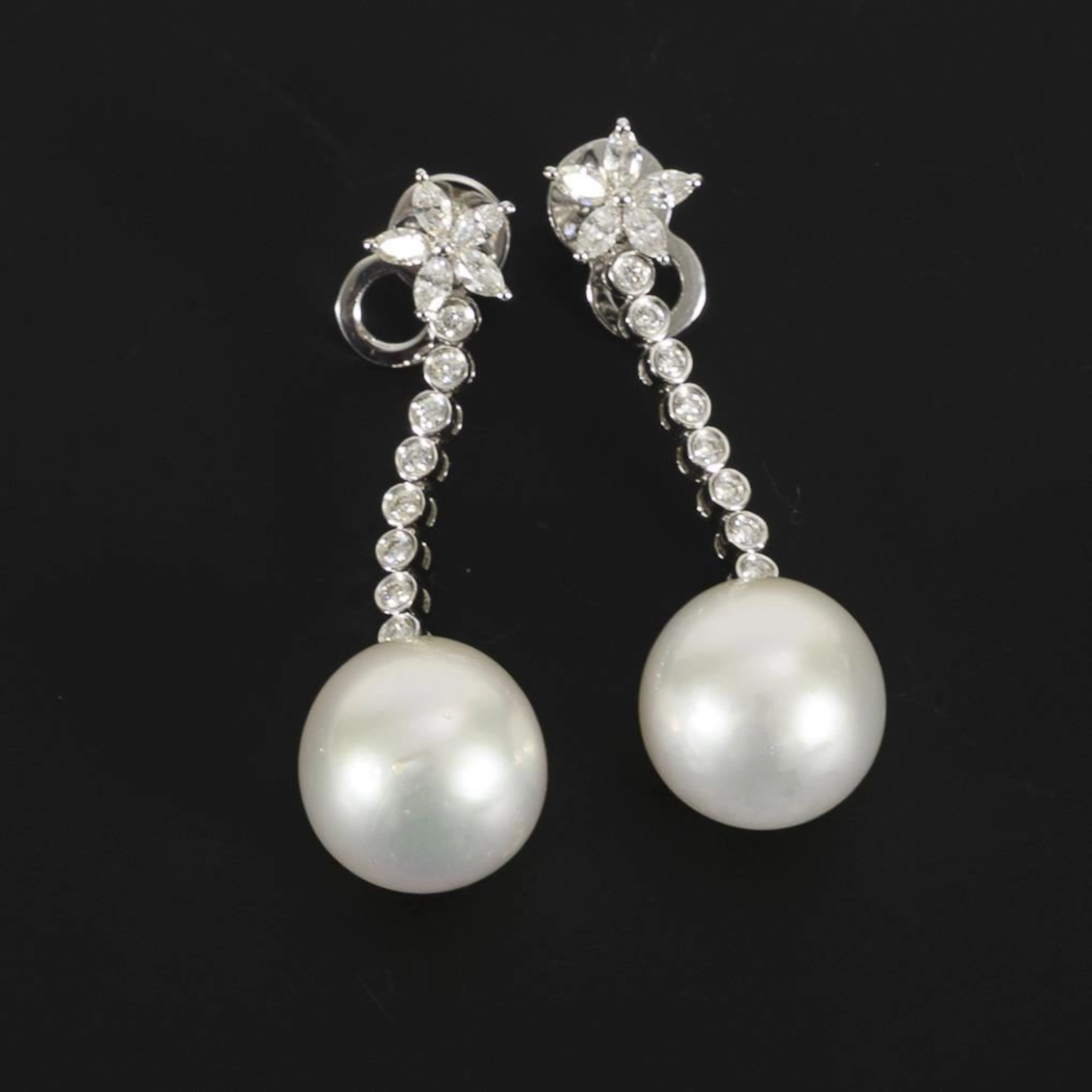High-quality dangling earrings with pearls, likely South Sea pearls.
