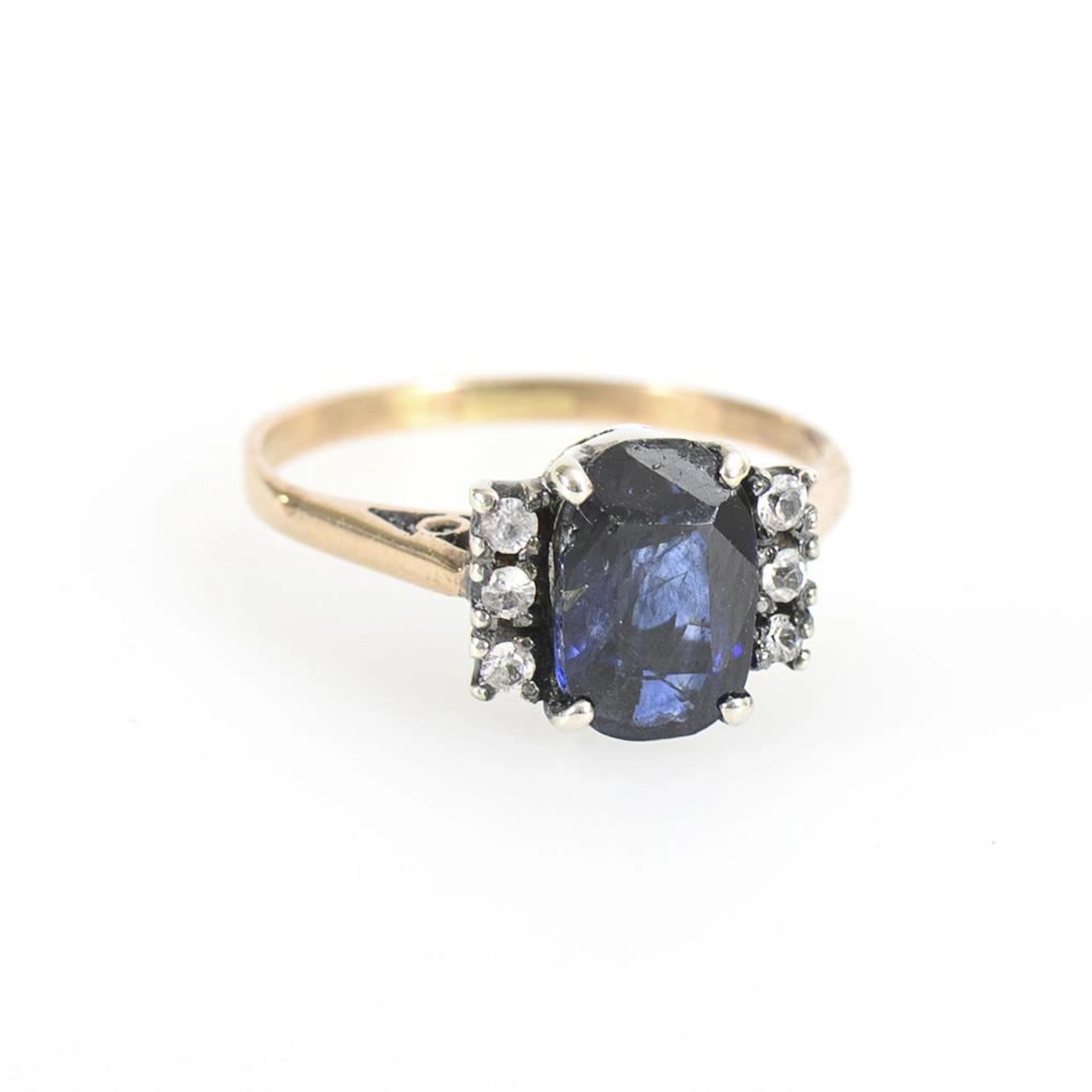 Ring with a blue gemstone or synthetic stone and diamond imitations.