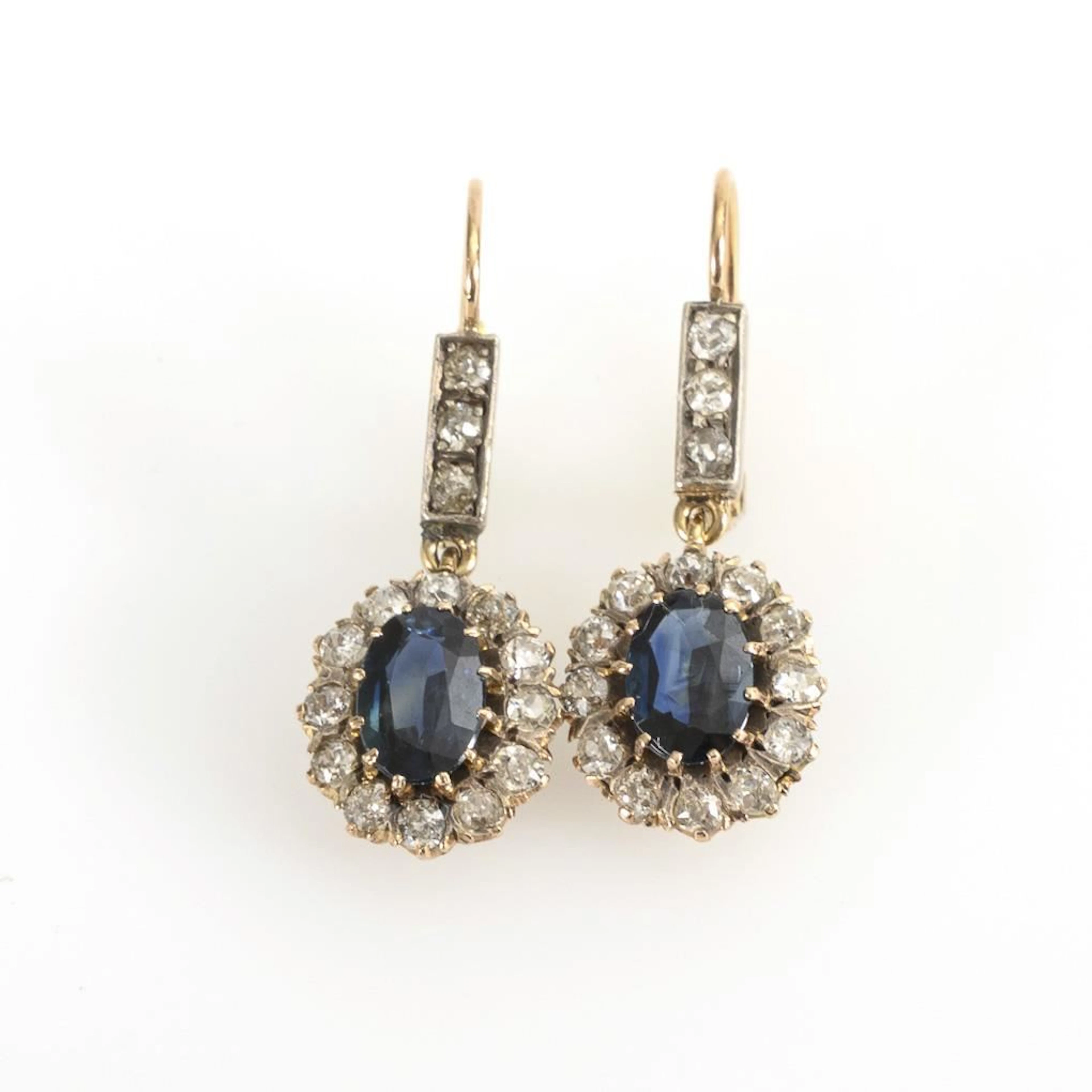Entourage earrings, likely sapphires and old-cut diamonds.