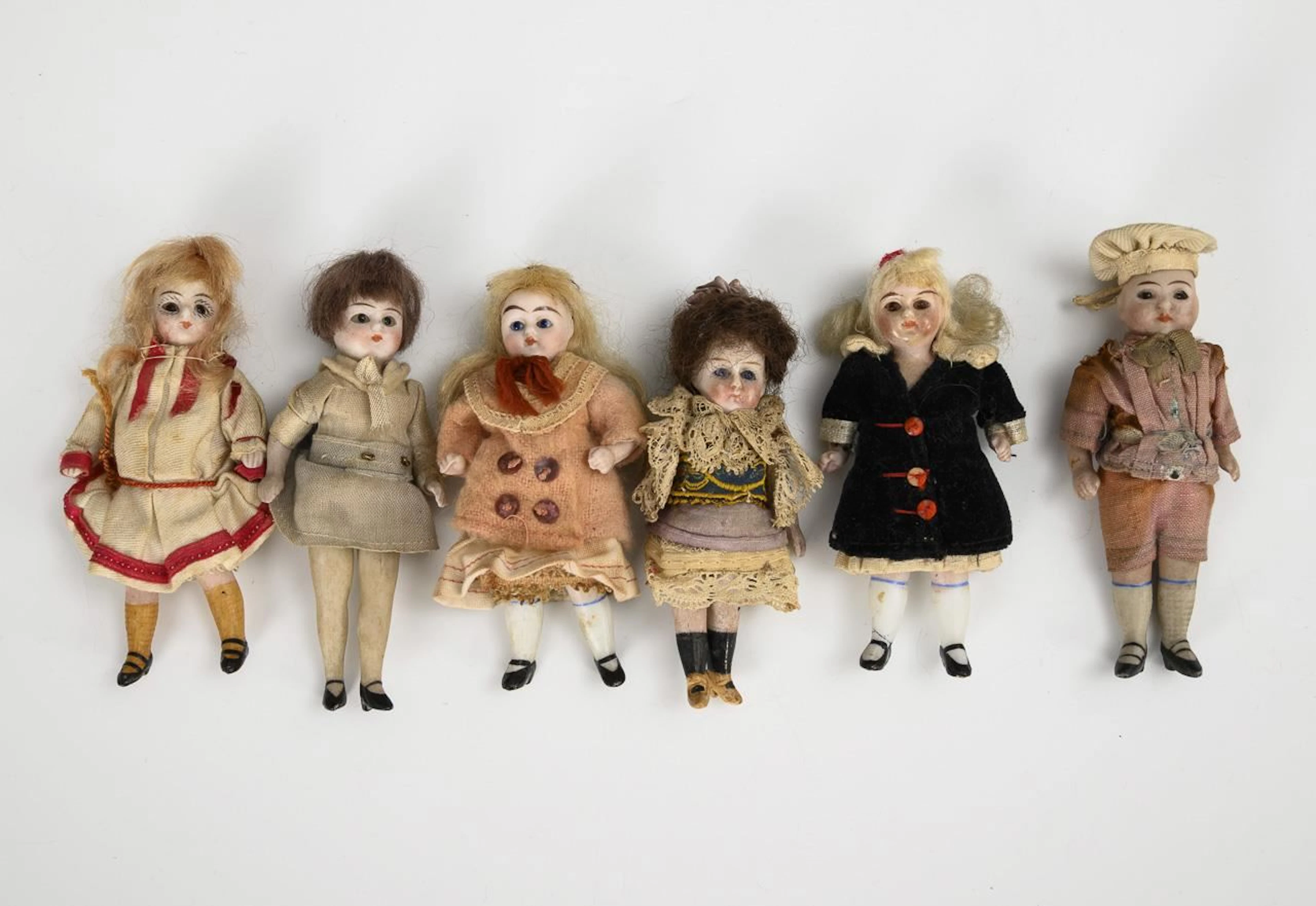 6 dollhouse dolls with glass eyes.