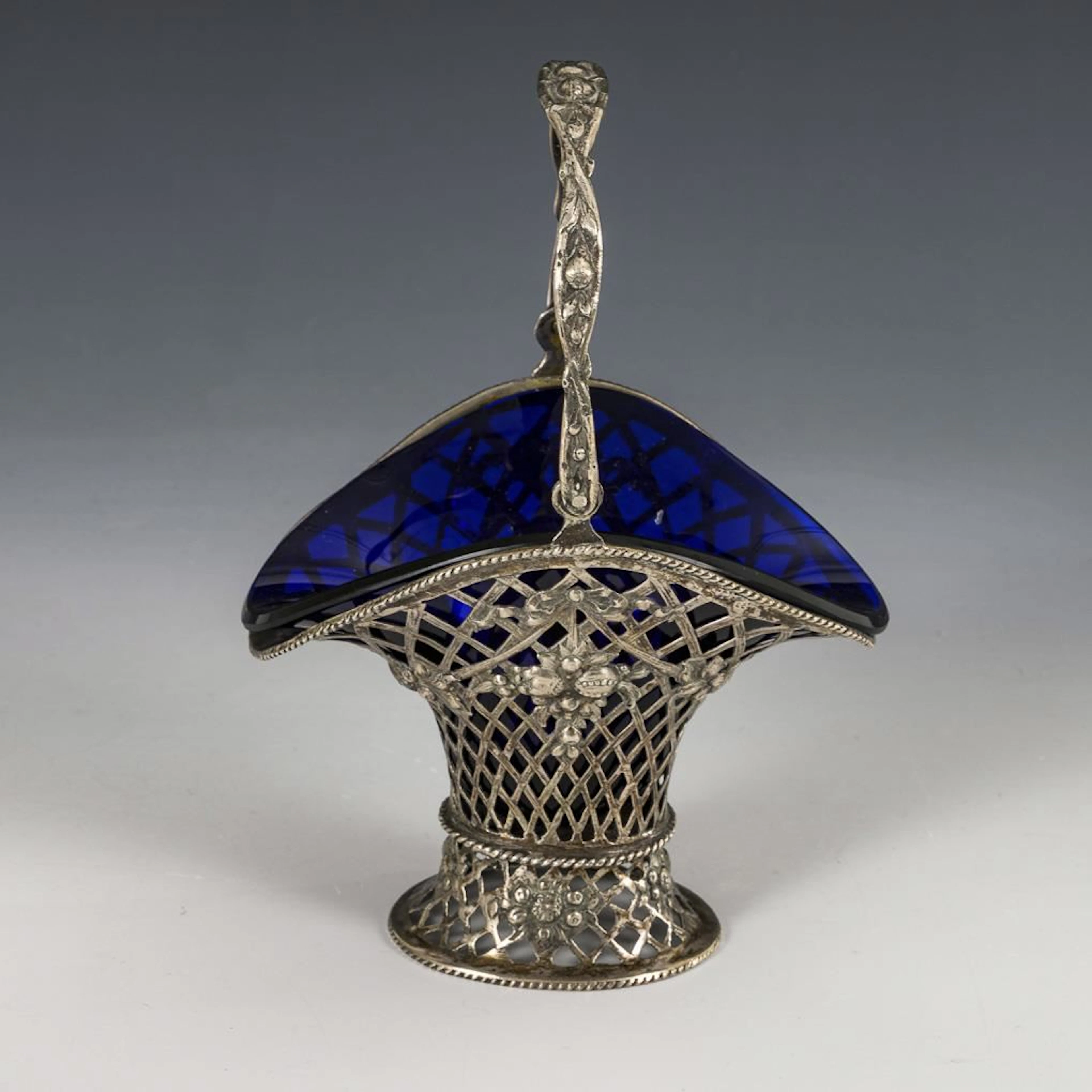 Silver handle basket with blue glass insert.