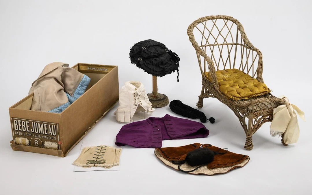 French chaise longue, original Bébé-Jumeau box, hat stand, and clothing.