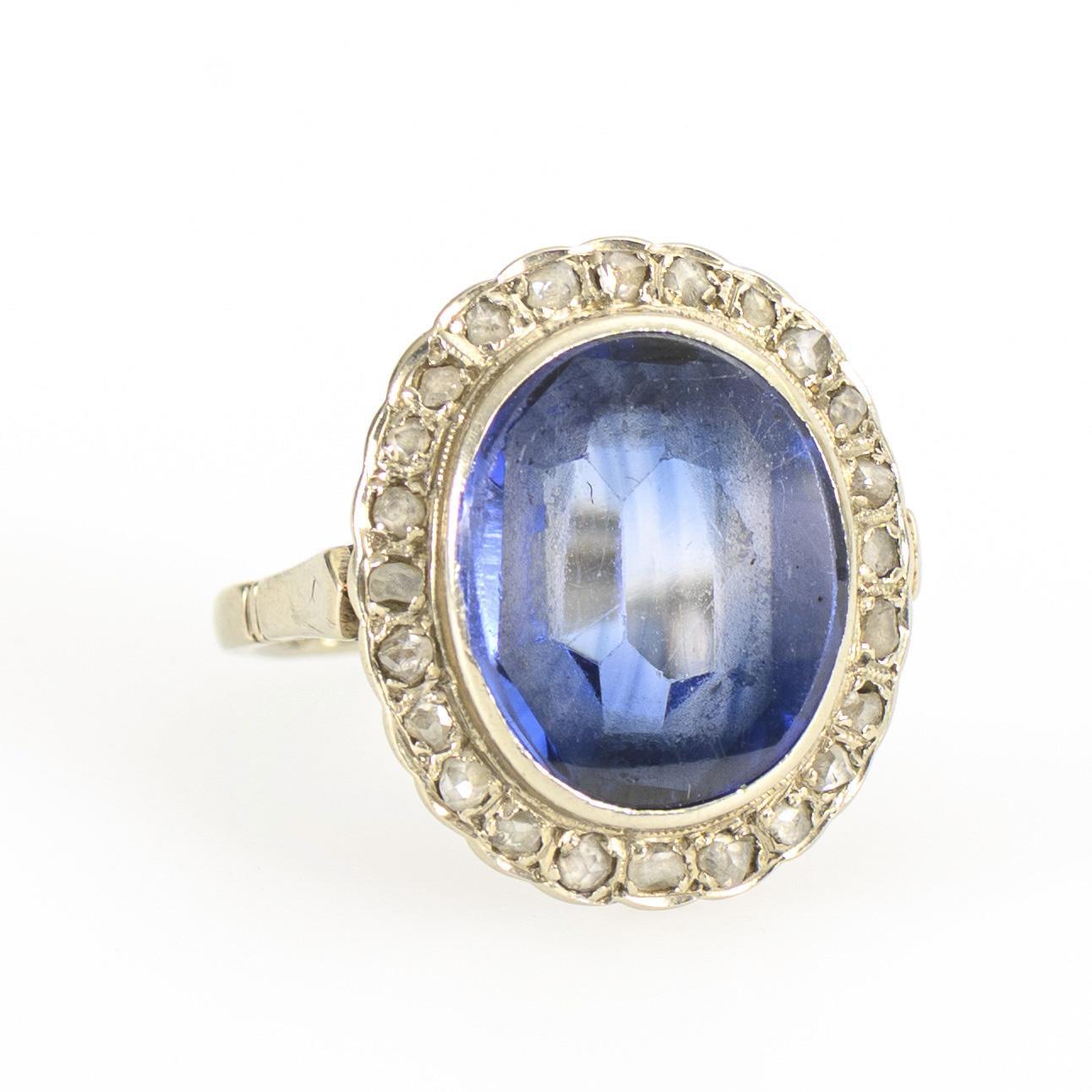 Entourage ring with blue colored stone, probably sapphire.