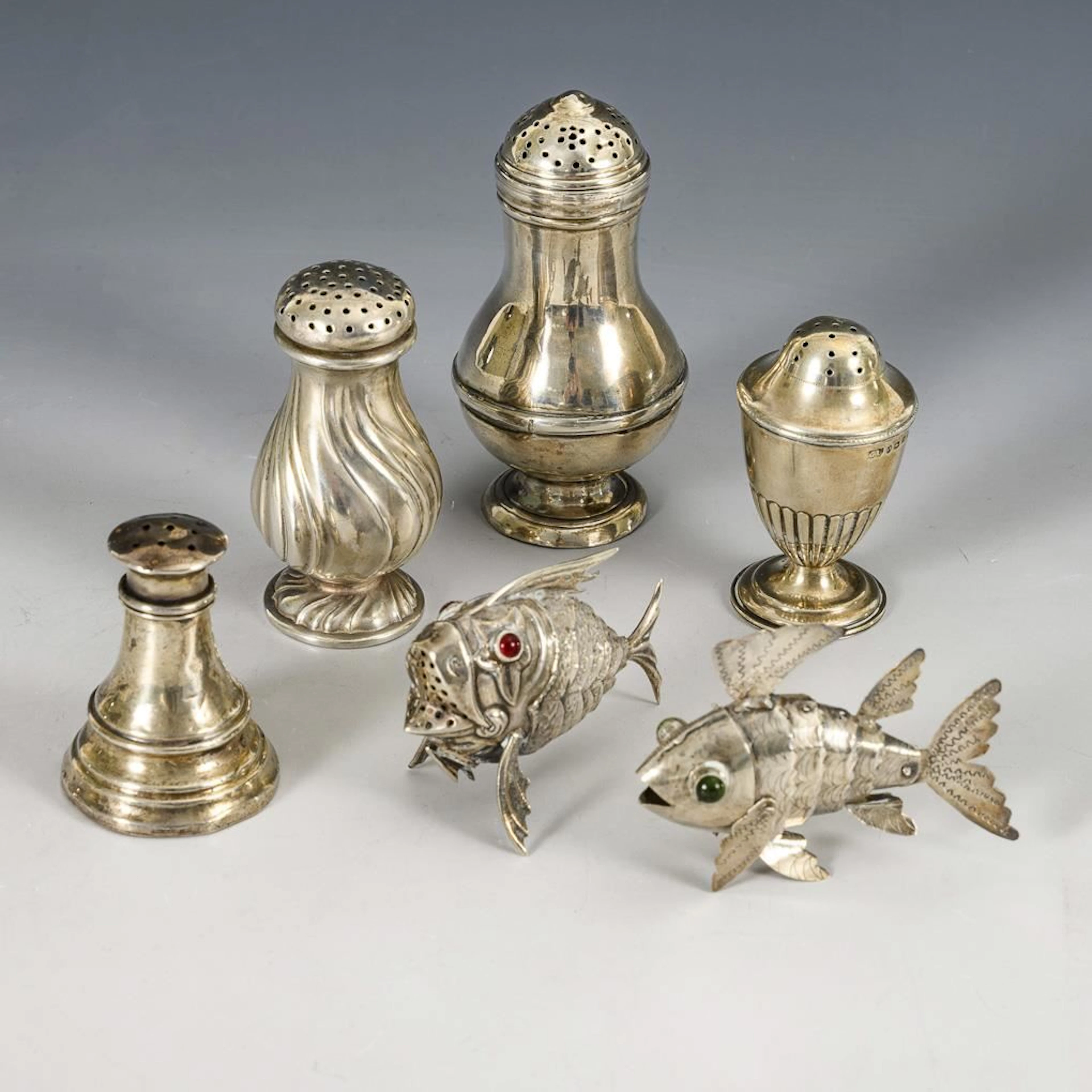 Set of 4 salt shakers and 2 small fish figurines.