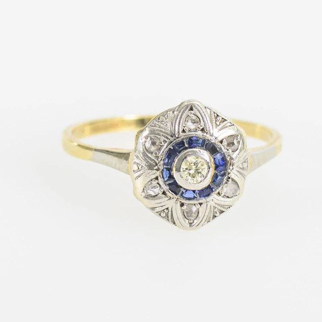 Round Art Deco ring with blue gemstones and a brilliant-cut diamond.