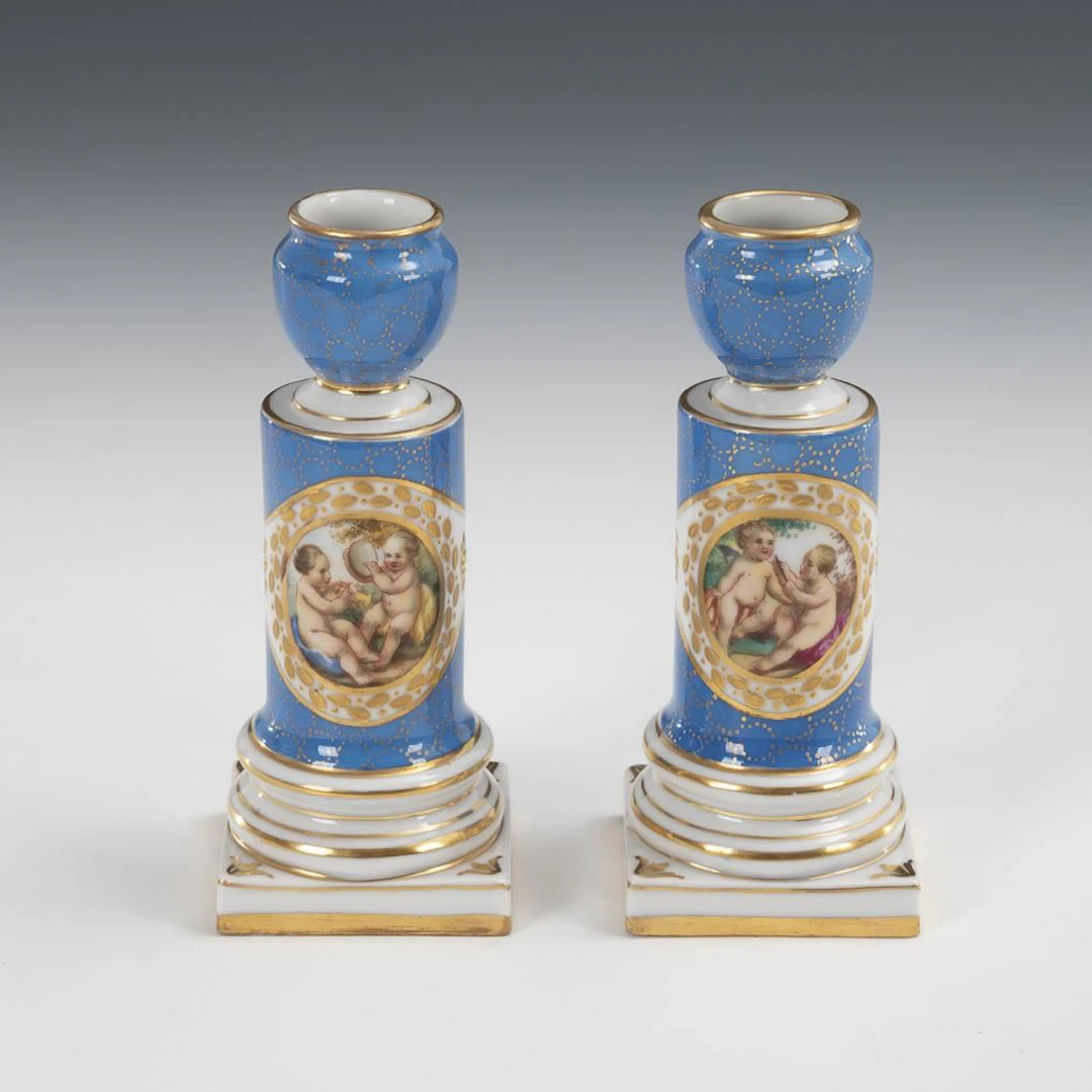 Pair of candlesticks featuring depictions of cherubs.