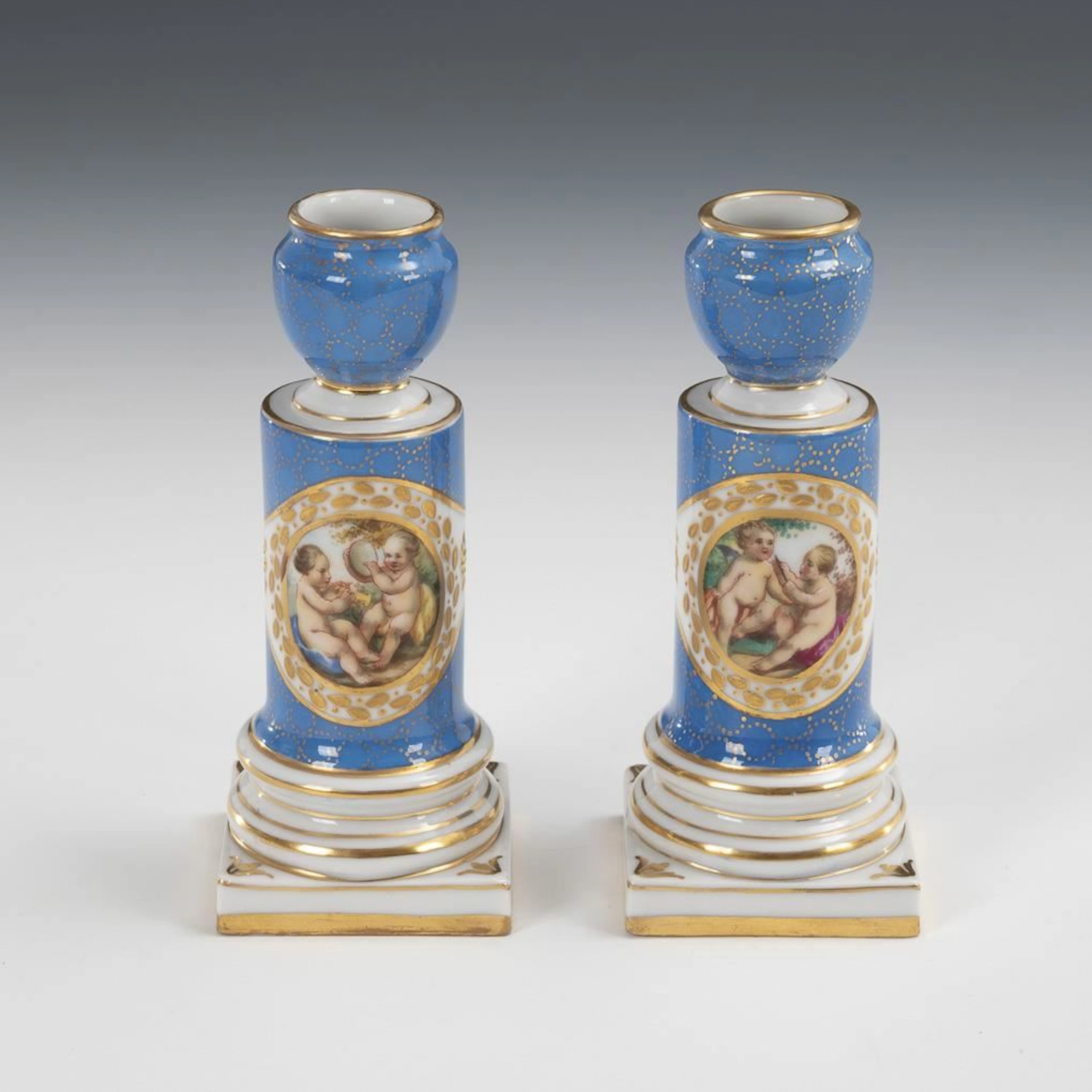 Pair of candlesticks featuring depictions of cherubs.