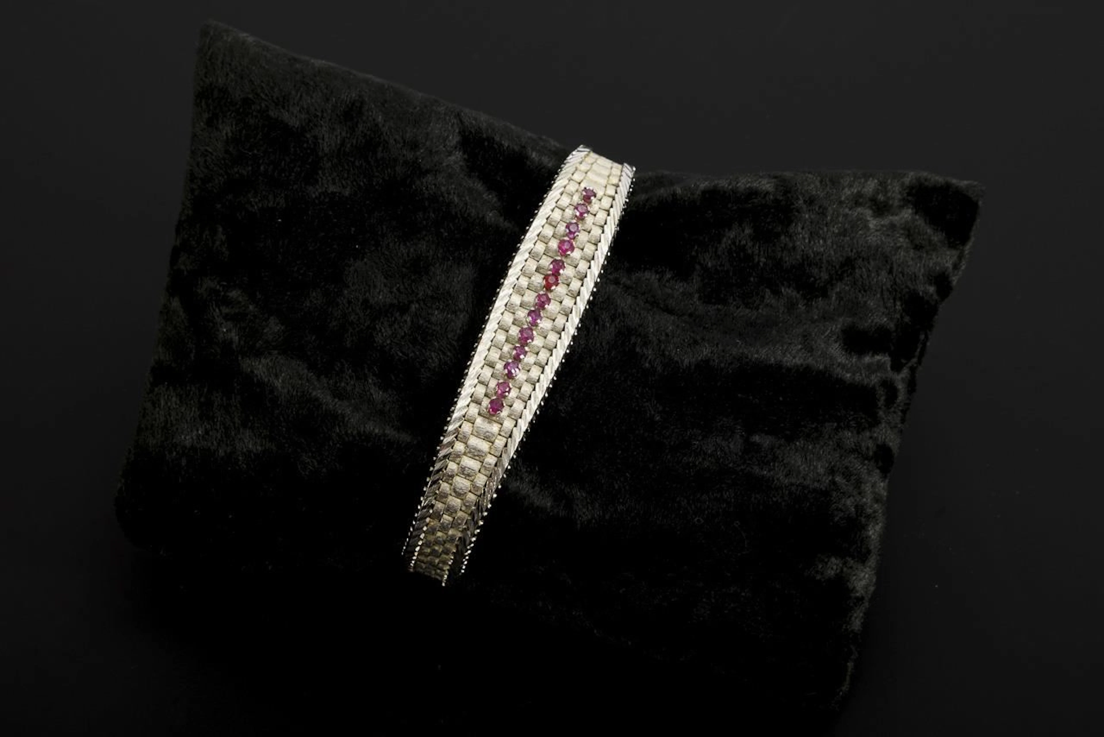 White gold bracelet with red gemstones, likely rubies.