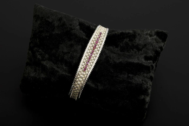 White gold bracelet with red gemstones, likely rubies.