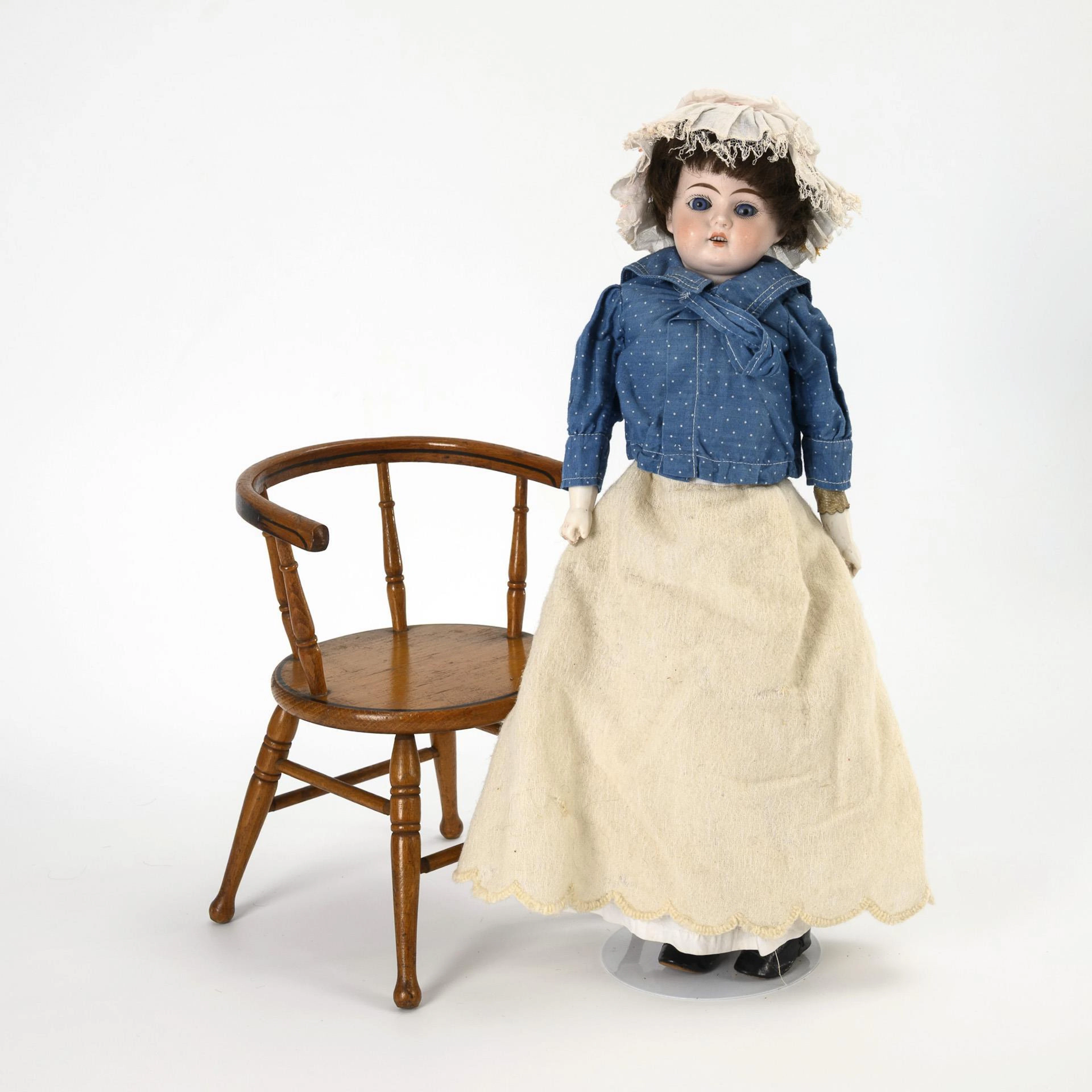 Chest head doll on wooden chair.