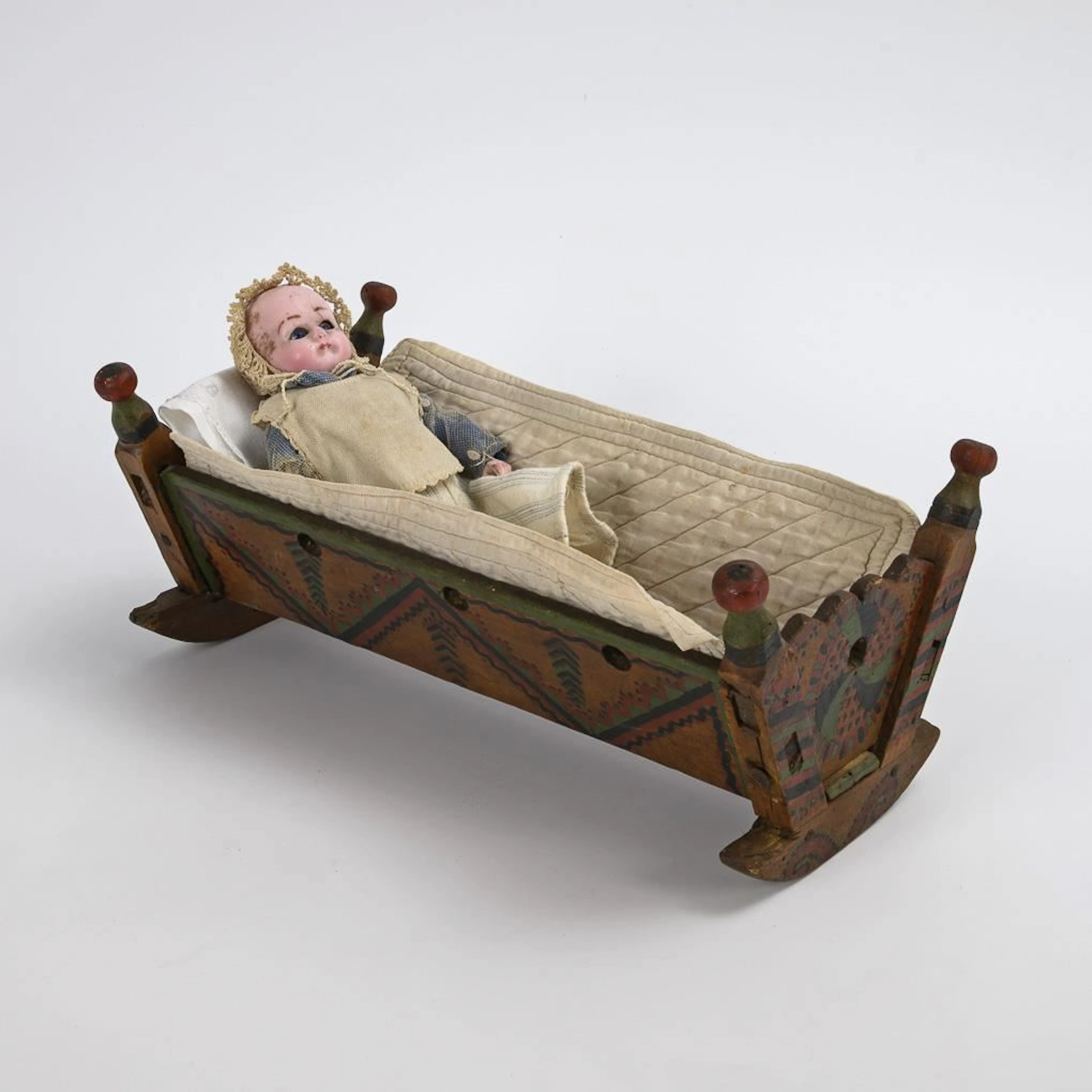 Sonneberg wax-headed doll in a cradle. Motschmann type.