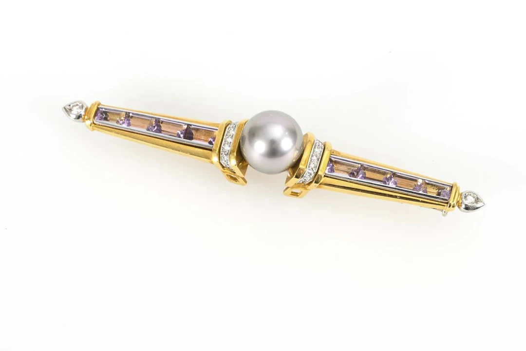 Bar brooch with amethysts, brilliant-cut diamonds, and a dark pearl.