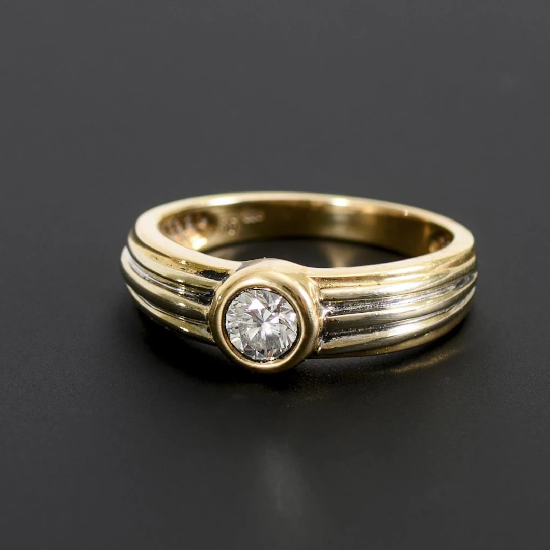 Band ring with a solitaire brilliant-cut diamond.