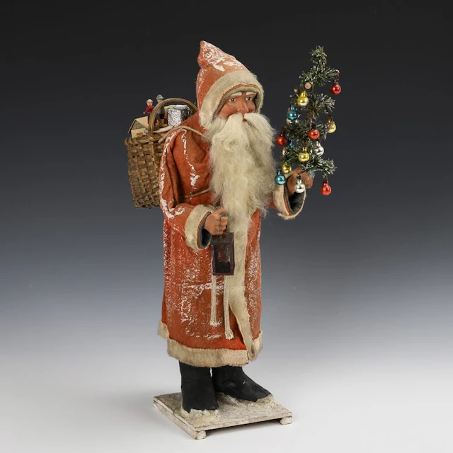 Large Santa Claus with a decorated little tree and a lantern.
